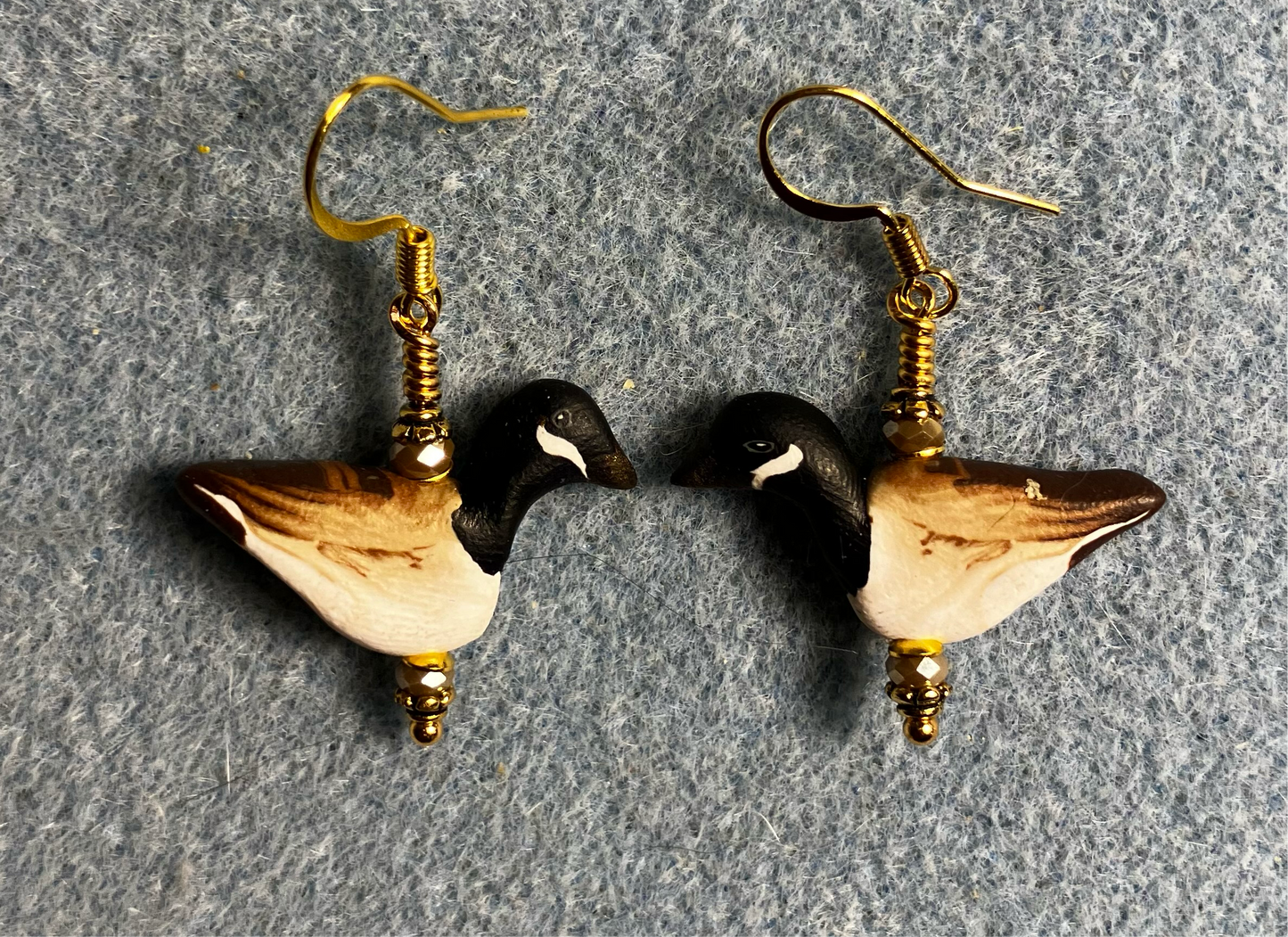 Black, brown, and tan polymer clay goose bead earrings adorned with tan Chinese crystal beads.