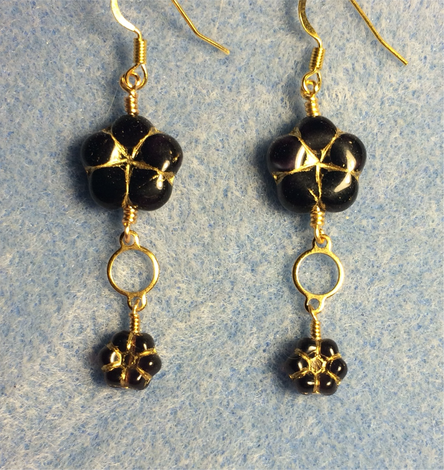 Dark purple Czech glass puffy flower bead earrings adorned with gold circle connectors and small dark purple Czech glass poppy beads.
