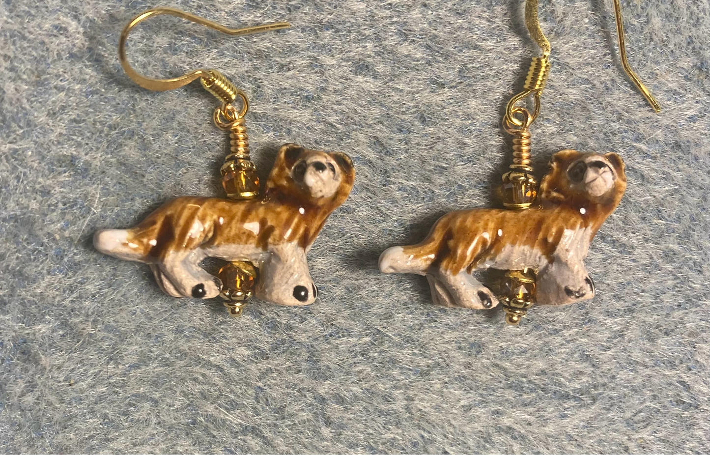 Small amber and beige ceramic lion bead earrings adorned with amber Chinese crystal beads.
