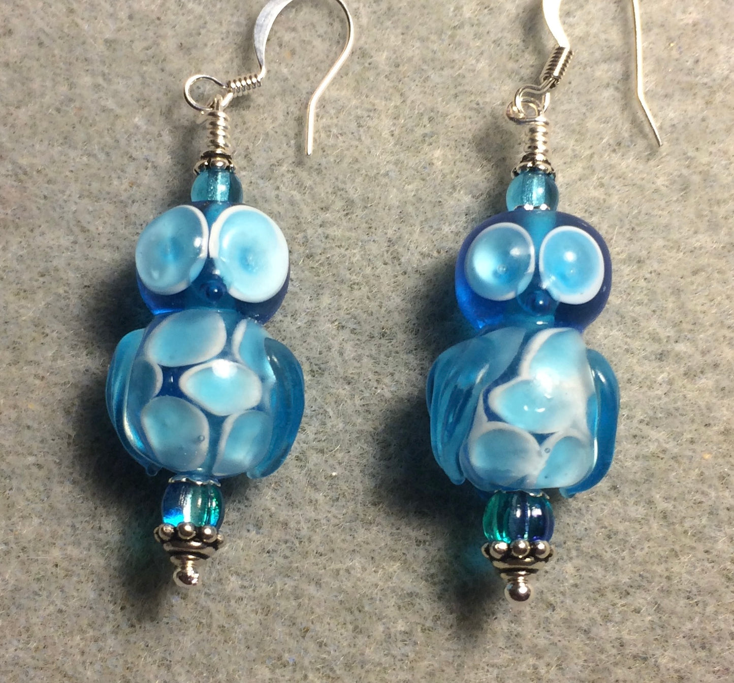 Turquoise lamp work owl bead earrings adorned with turquoise Czech glass beads.
