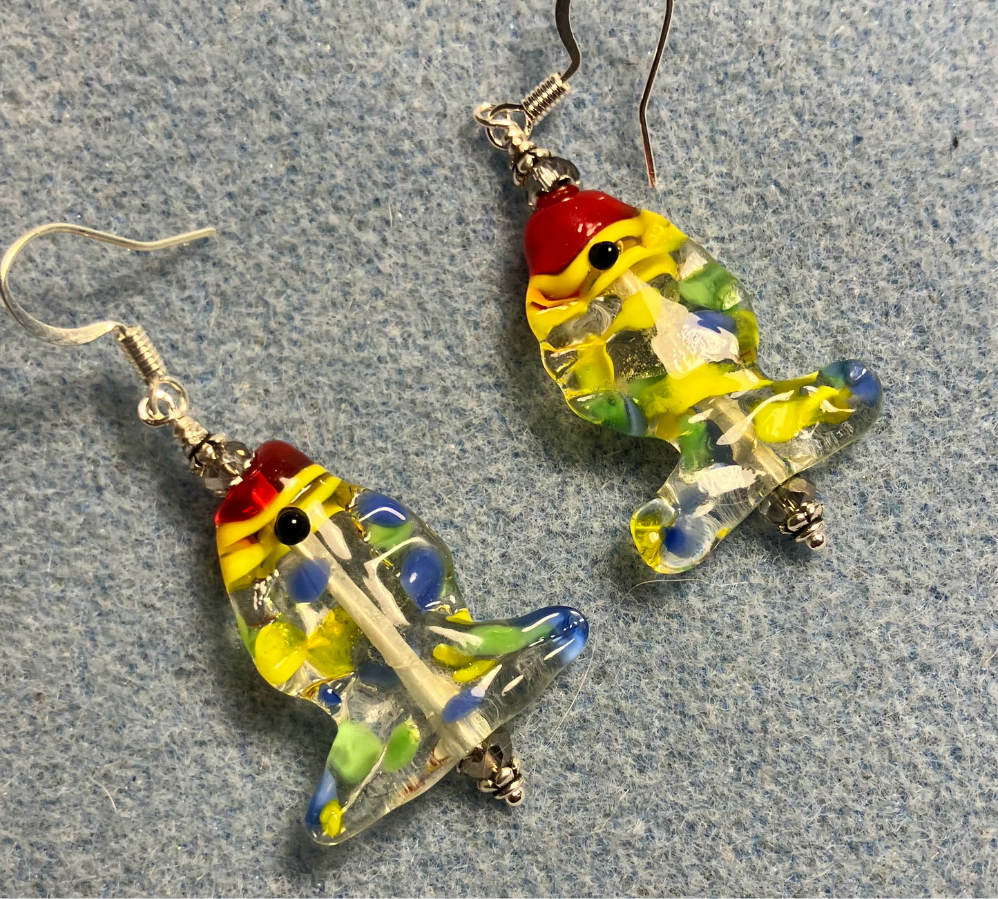Colorful yellow, red, and blue lamp work fish bead earrings adorned with clear Chinese crystal beads.