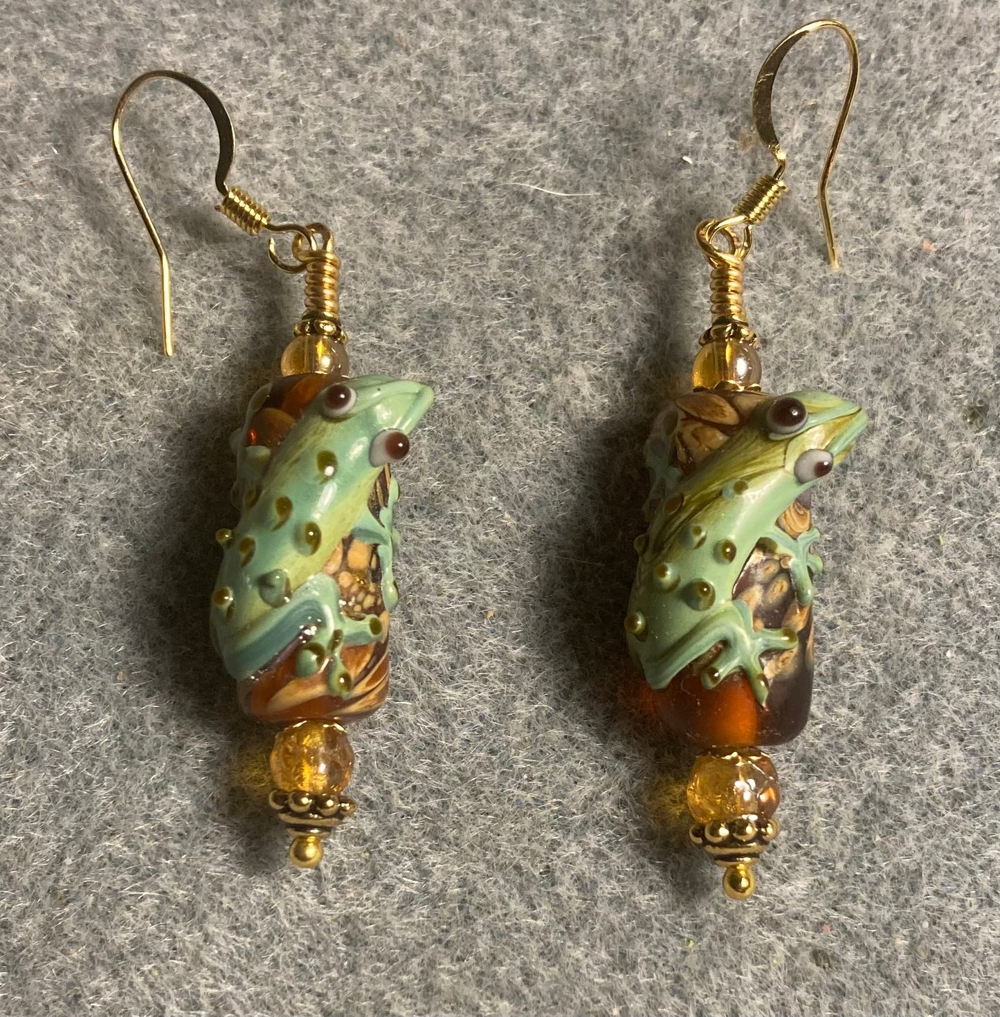 Topaz and green lamp work lizard bead earrings adorned with topaz Czech glass beads.