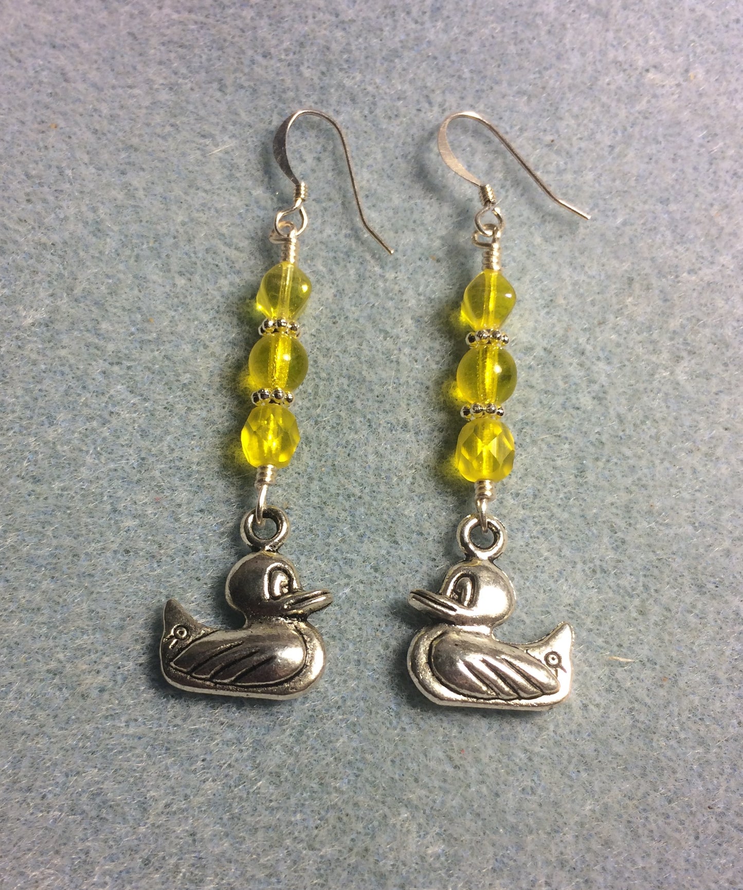 Silver duck charm earrings adorned with yellow Czech glass beads