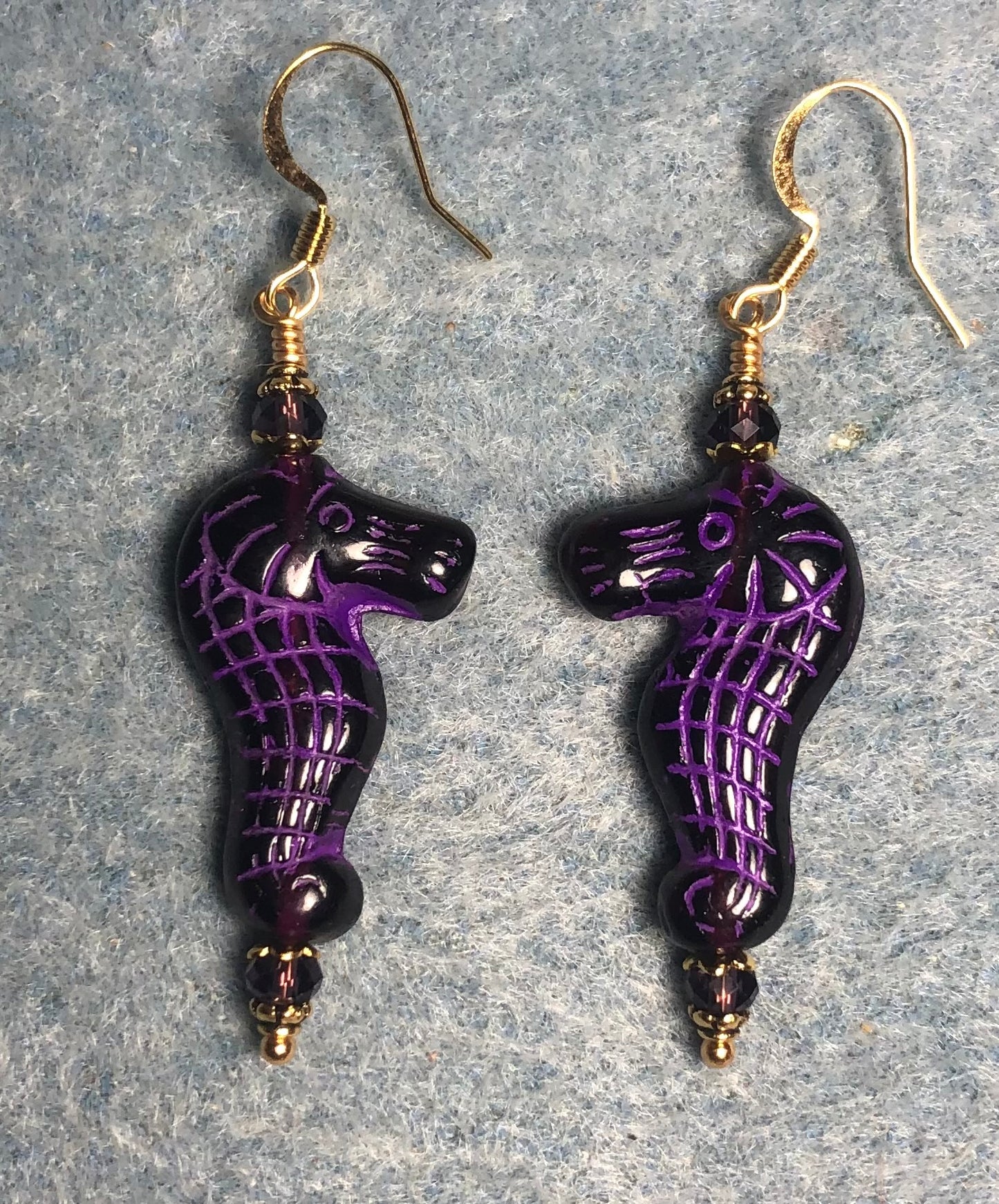 Dark purple (with violet inlay) Czech glass seahorse bead earrings adorned with purple Chinese crystal beads.