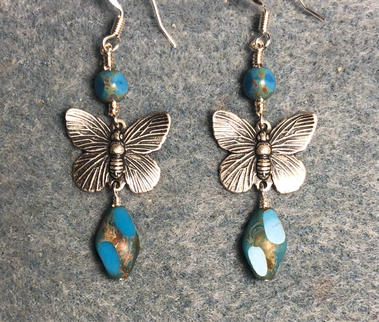 Silver butterfly connector charm earrings adorned with light blue Czech glass twist beads and light blue Czech glass beads.