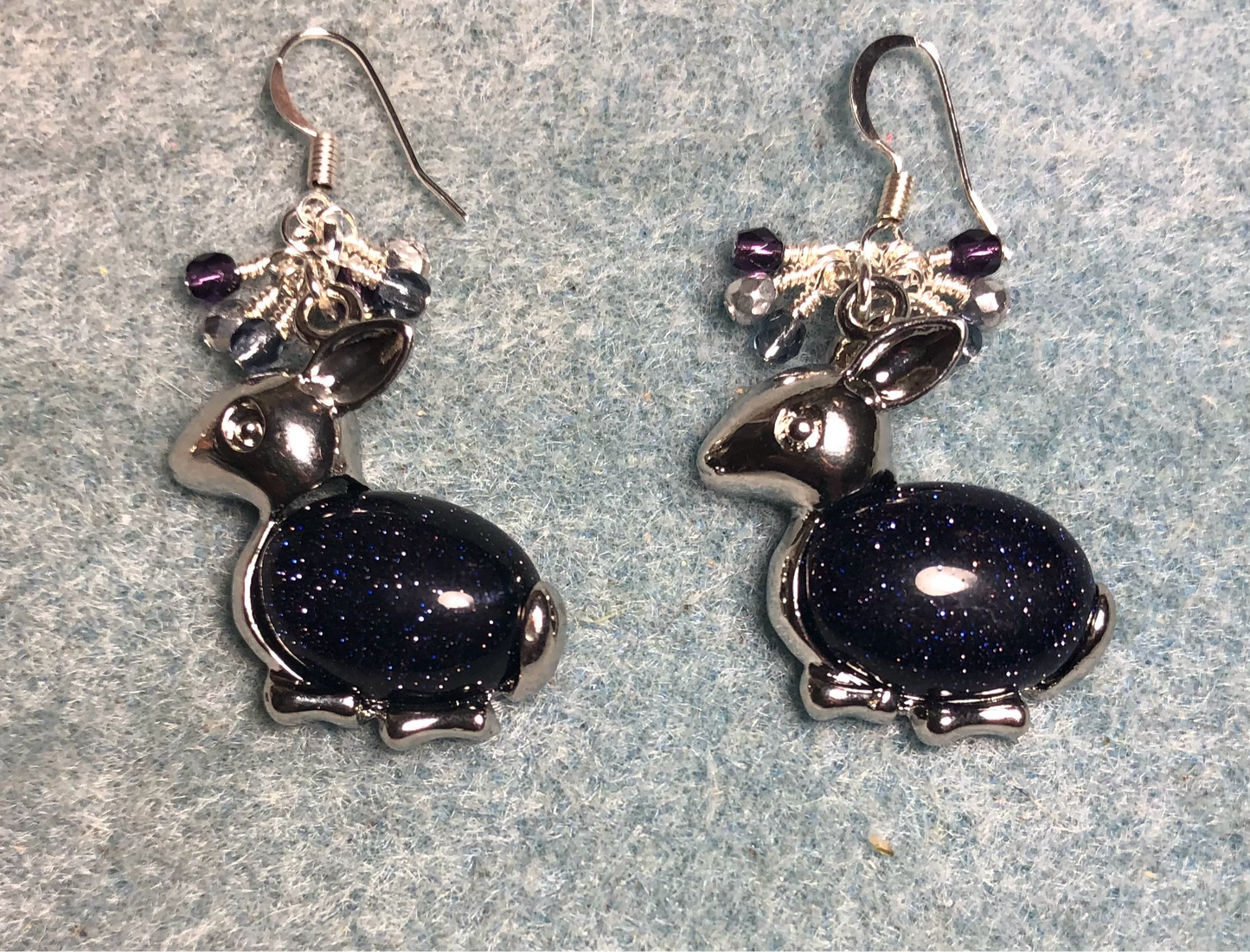 Large silver and blue goldstone gemstone rabbit charm earrings adorned with small dangling purple and silver Czech glass beads.