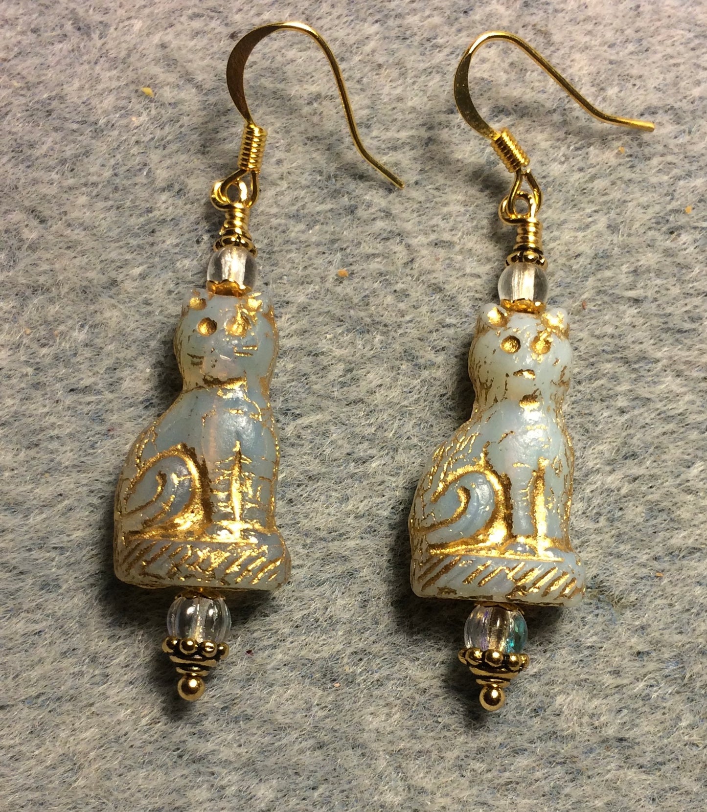 Opaque off white (with gold inlay) fancy Czech glass cat bead earrings adorned with clear Czech glass beads.
