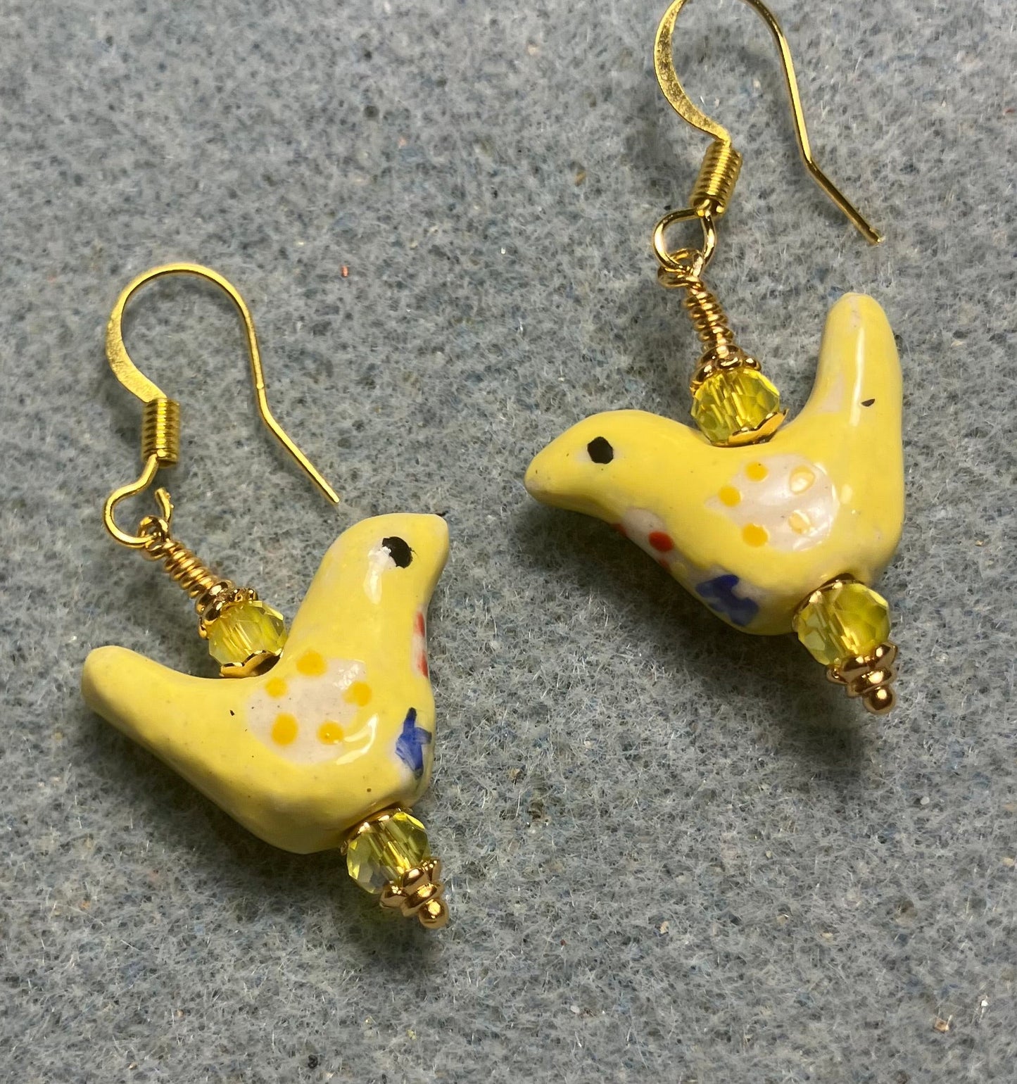 Small yellow, white, and blue ceramic bird bead earrings adorned with yellow Chinese crystal beads.
