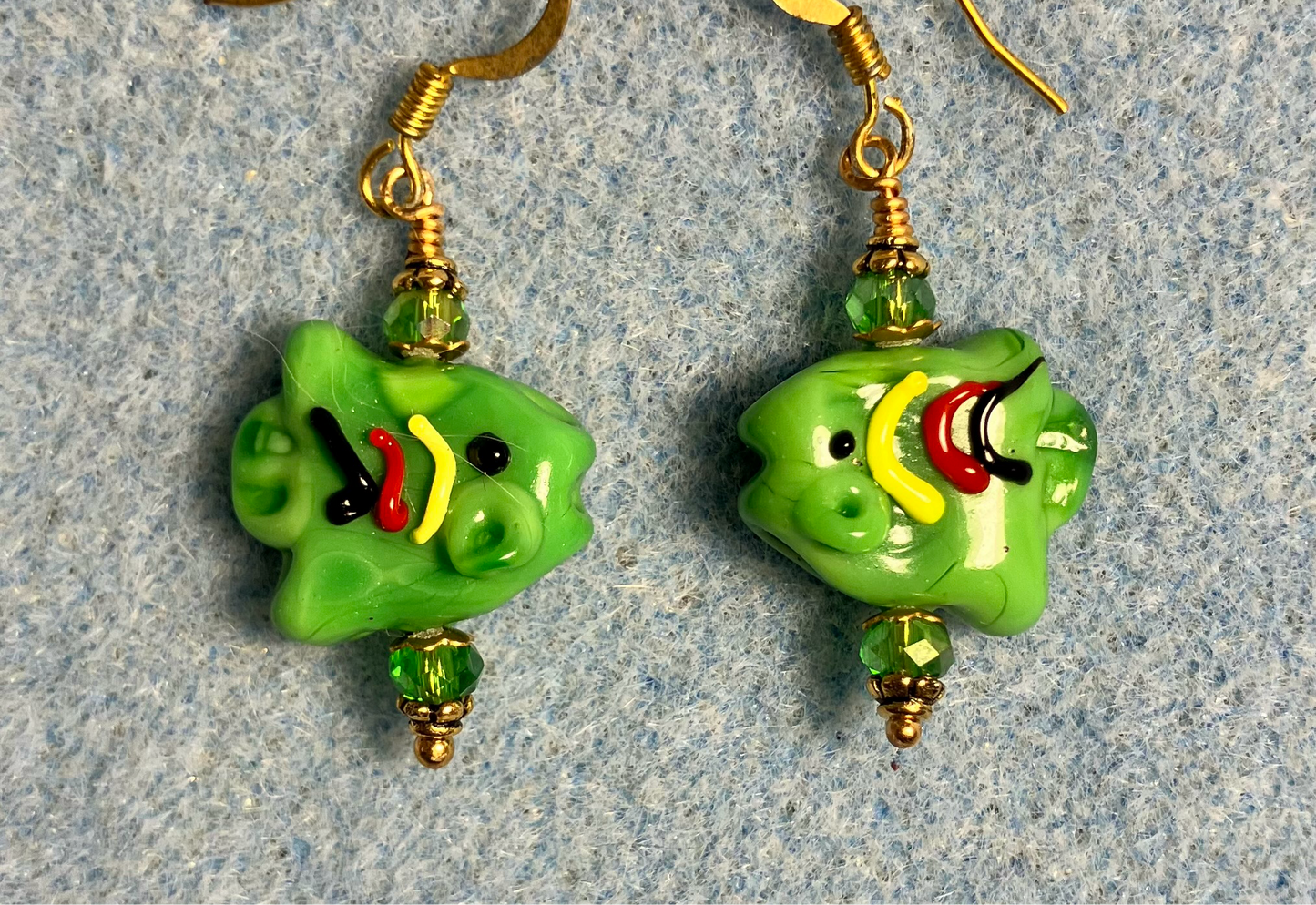 Opaque green lamp work fish bead earrings adorned with green Chinese crystal beads.