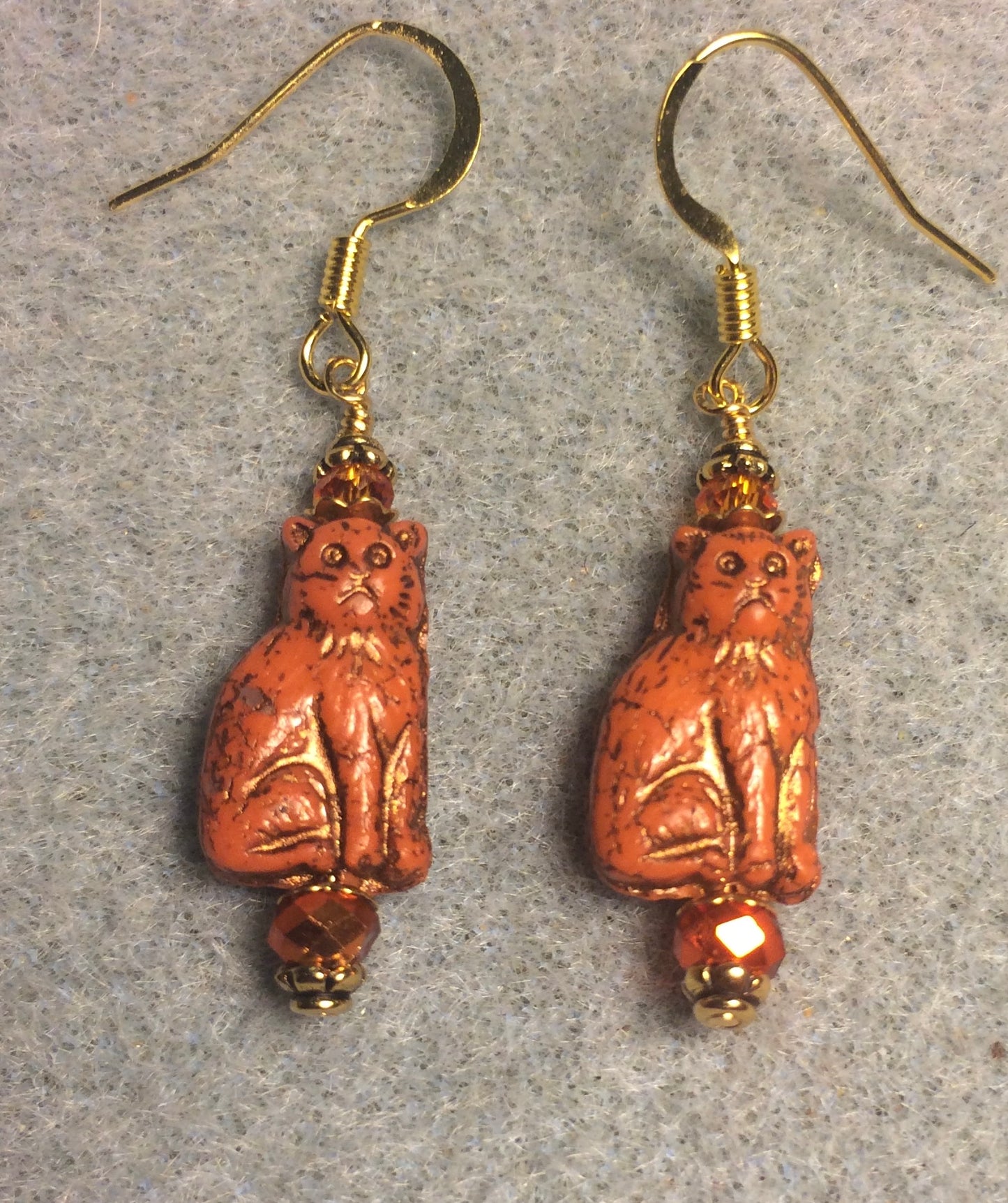 Small opaque orange Czech glass cat bead earrings adorned with sparkly orange Chinese crystal beads.
