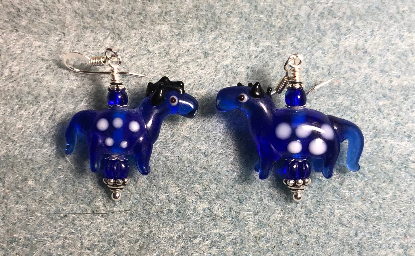 Translucent dark blue lamp work spotted horse bead earrings adorned with dark blue Czech glass beads.