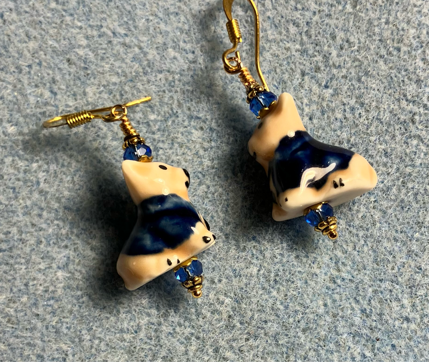 Tan and dark blue ceramic puppy dog bead earrings adorned with dark blue Chinese crystal beads.