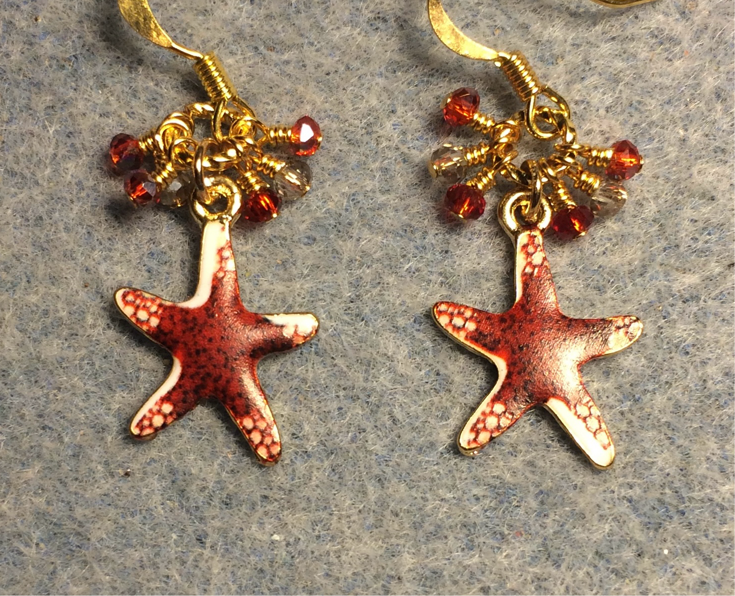 Dark red enamel starfish charm earrings adorned with tiny dangling dark red and amber Chinese crystal beads.