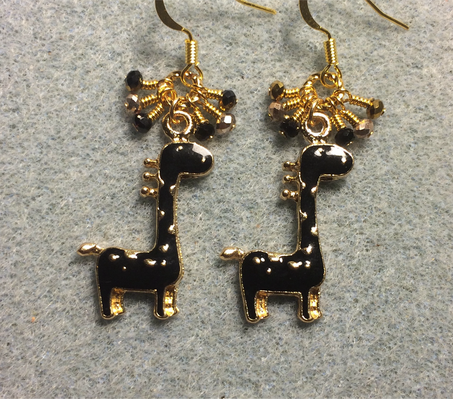 Black enamel spotted giraffe charm earrings adorned with tiny dangling black and gold Chinese crystal beads.