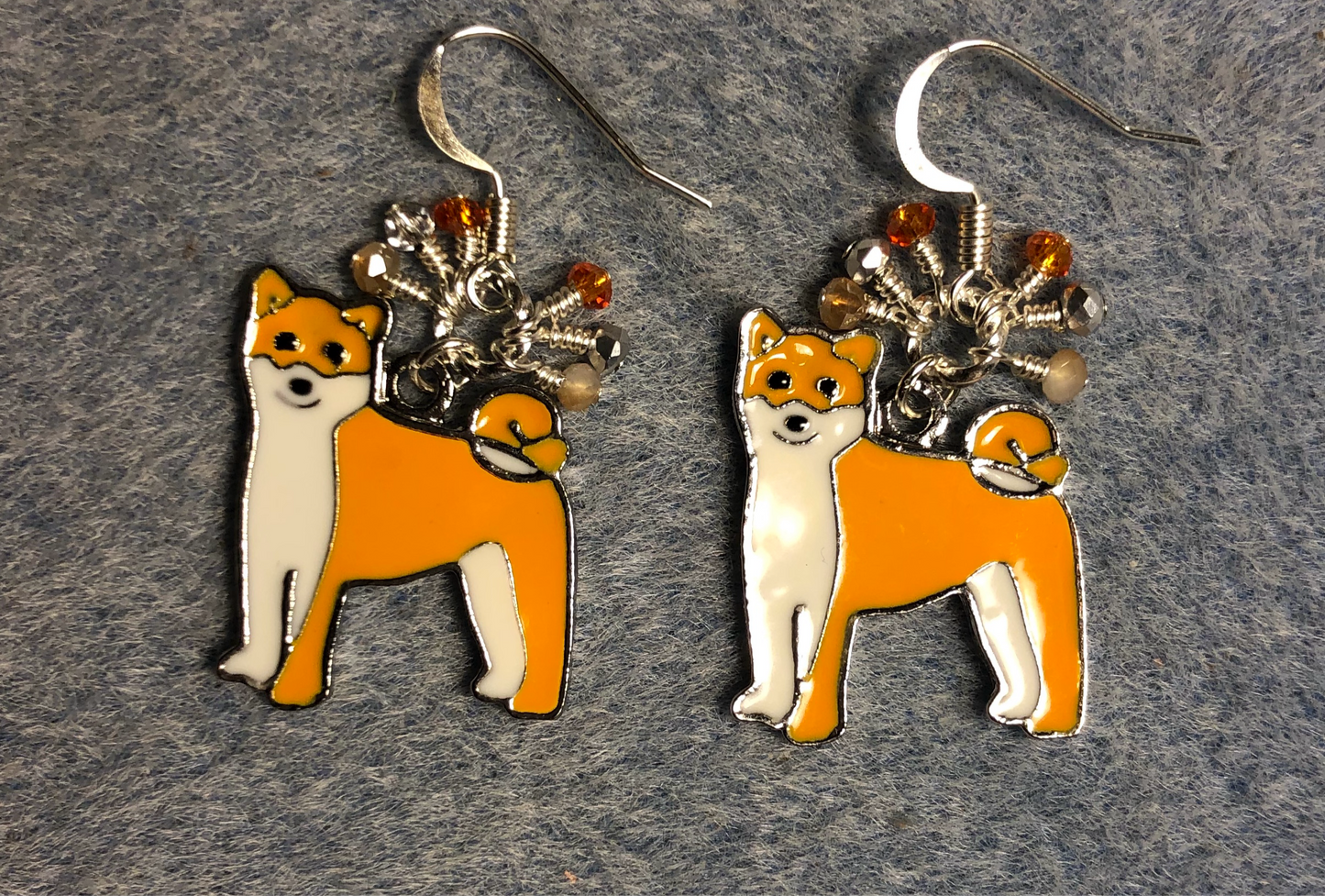 Orange and white enamel Shiba Inu charm earrings adorned with tiny dangling orange, peach, and silver Chinese crystal beads.