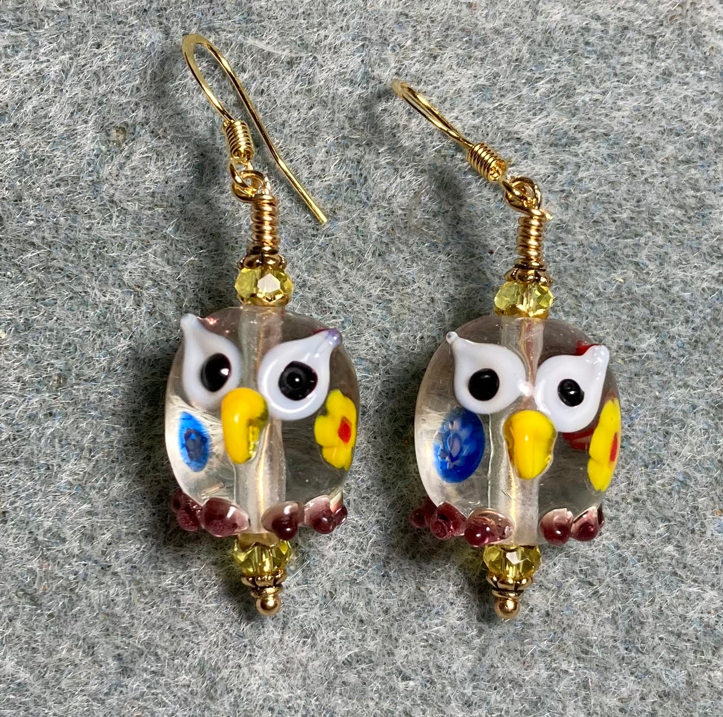 Clear lamp work spotted lamp work owl bead earrings adorned with yellow Chinese crystal beads.