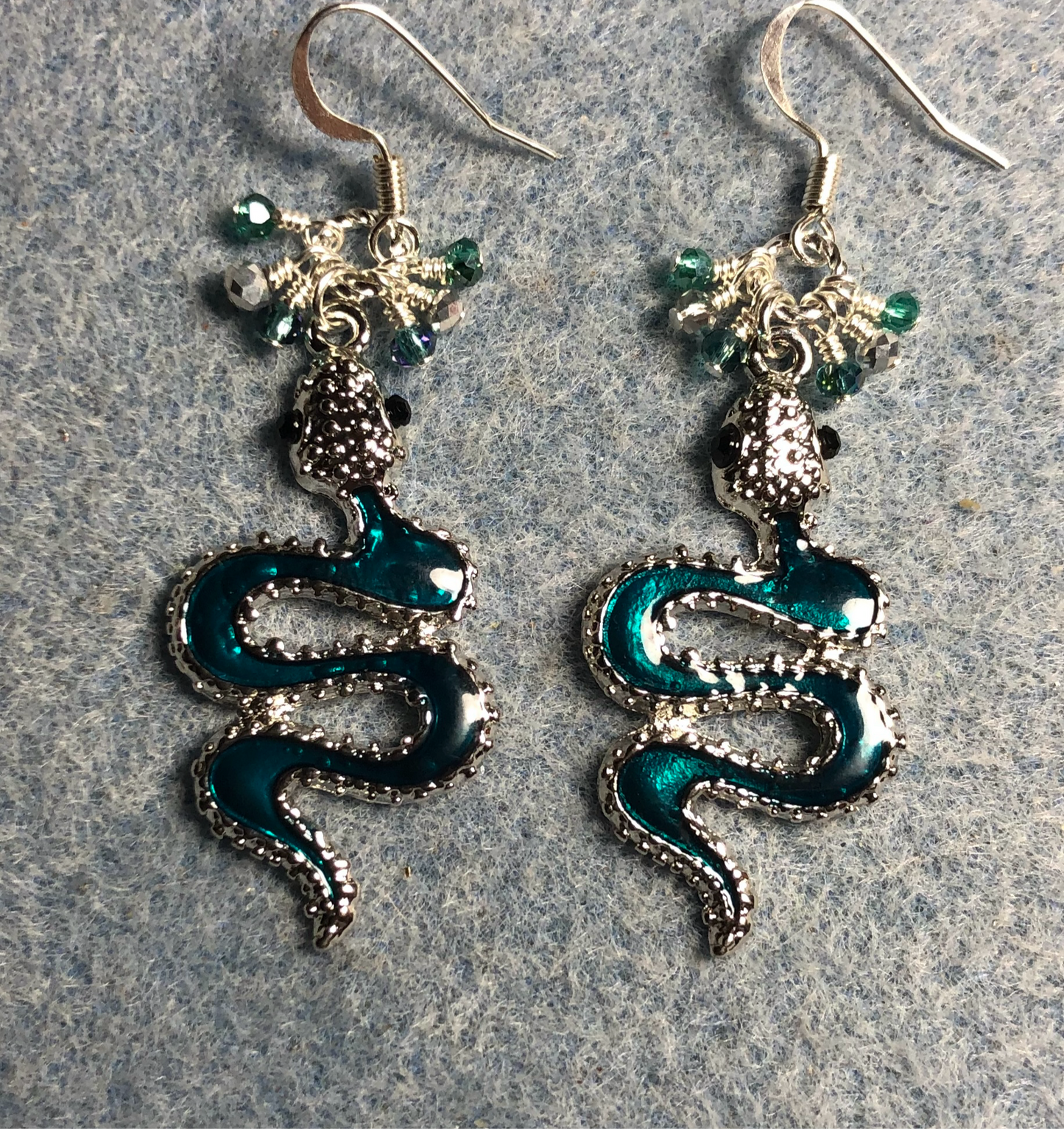 Teal enamel coiled snake charm earrings adorned with tiny dangling teal and silver Chinese crystal beads.