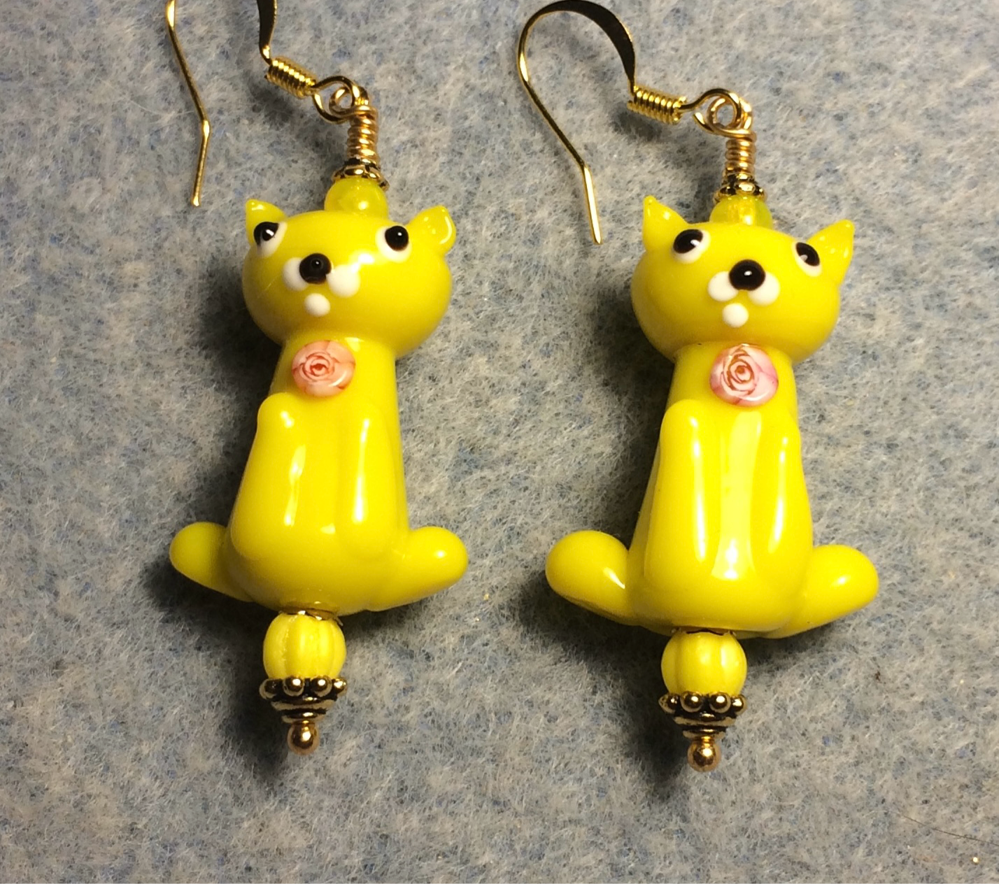Opaque yellow lamp work cat bead earrings adorned with yellow Czech glass beads.