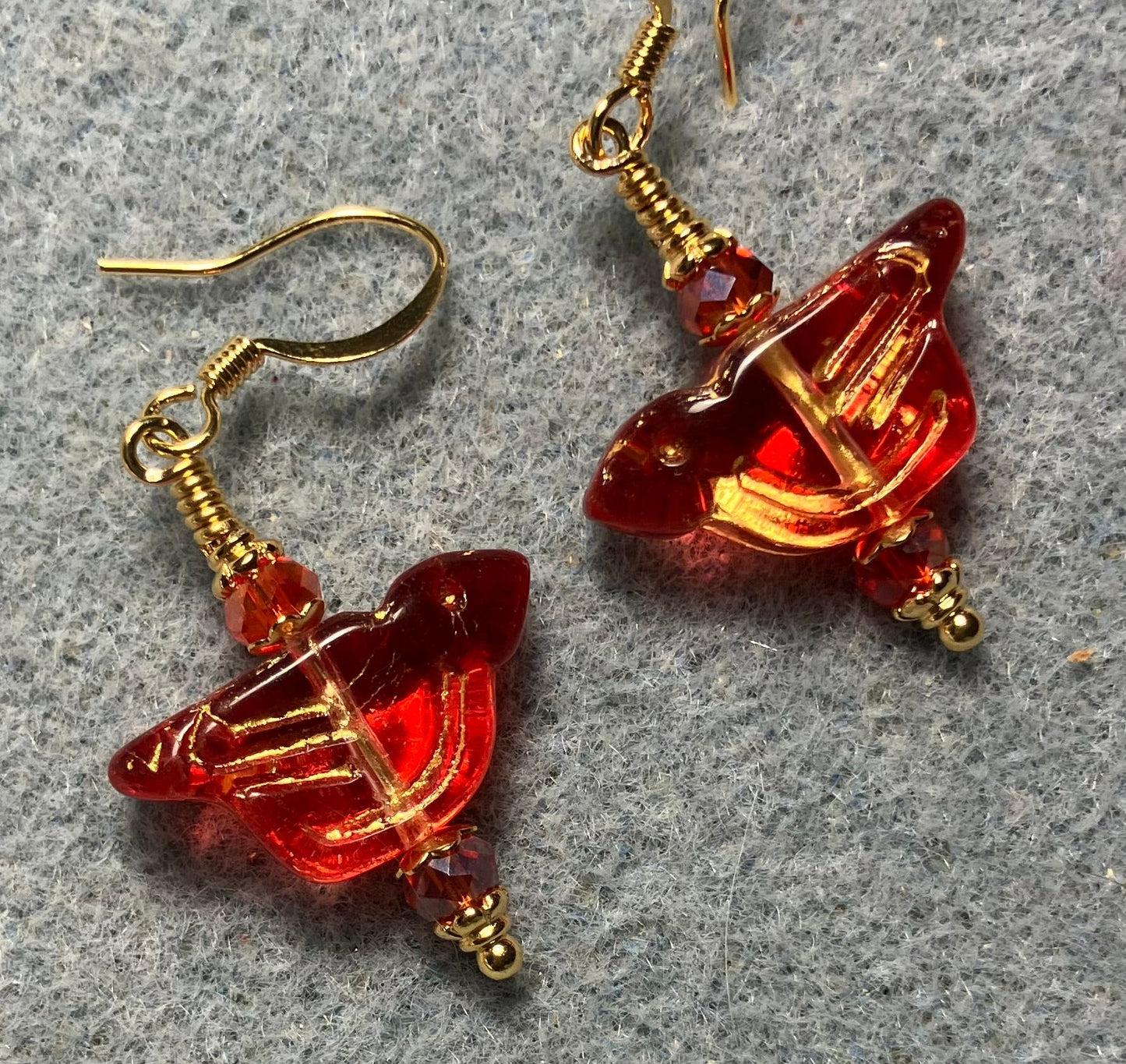 Translucent red (with gold wash) Czech glass bird bead earrings adorned with red Chinese crystal beads.