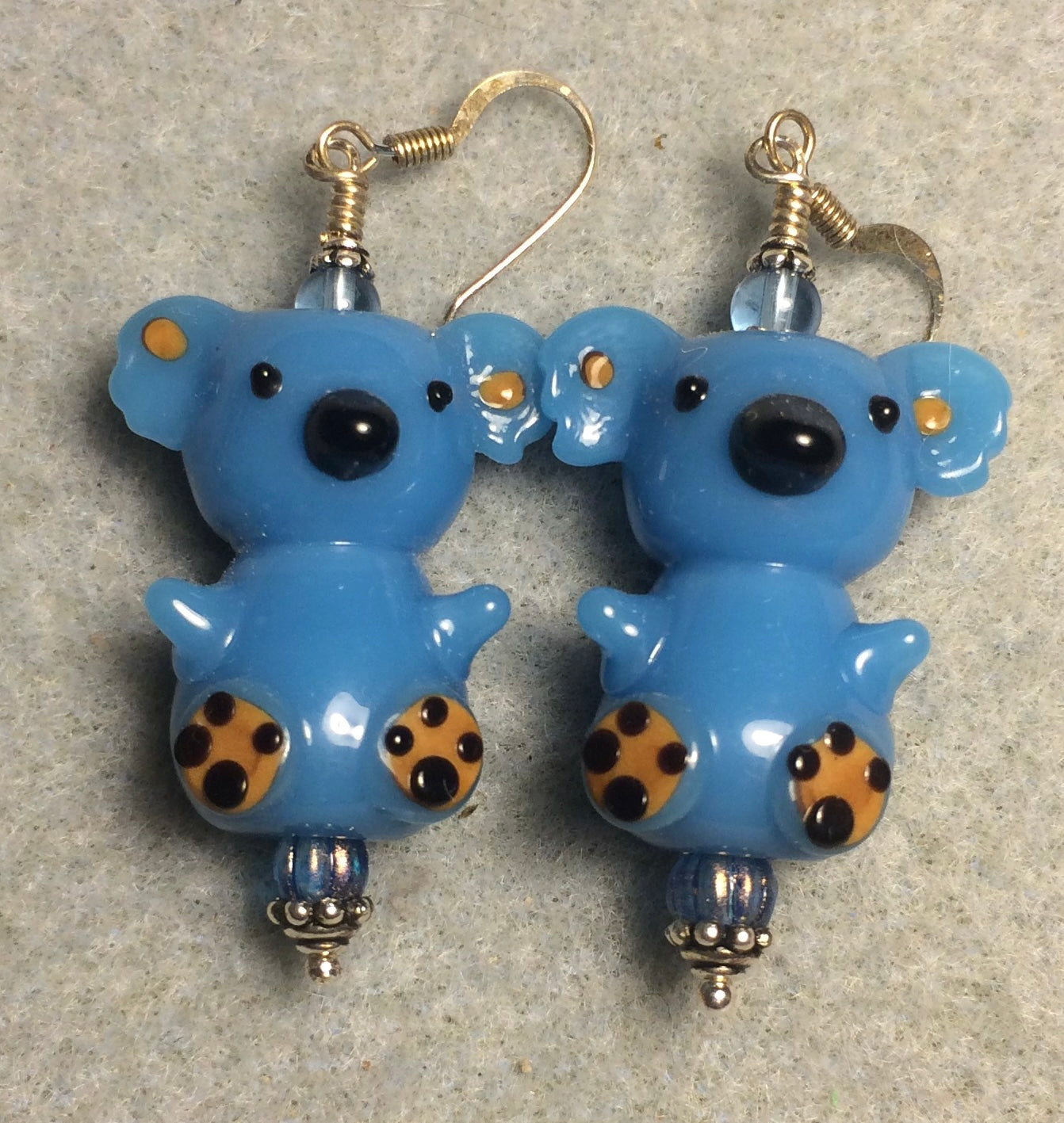 Large blue lamp work koala bear bead earrings adorned with blue Czech glass beads.