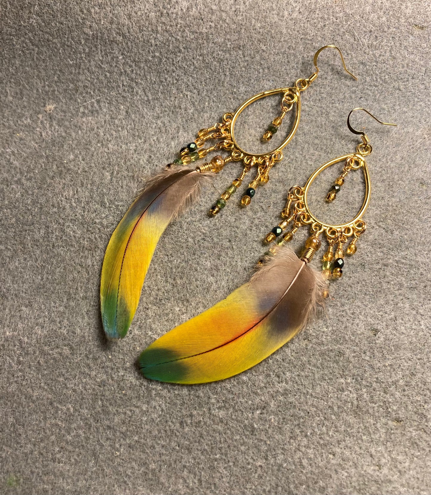 Yellow and green scarlet macaw feather earrings on gold chandelier findings adorned with tiny dangling topaz and green Czech glass beads.