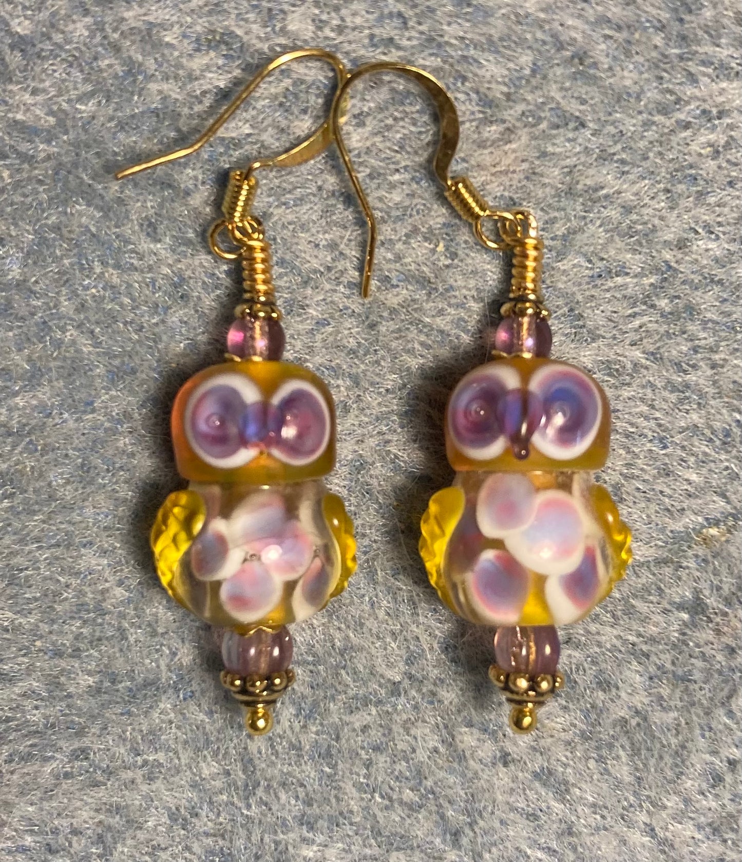 Amber and purple lamp work owl bead earrings adorned with purple Czech glass beads.