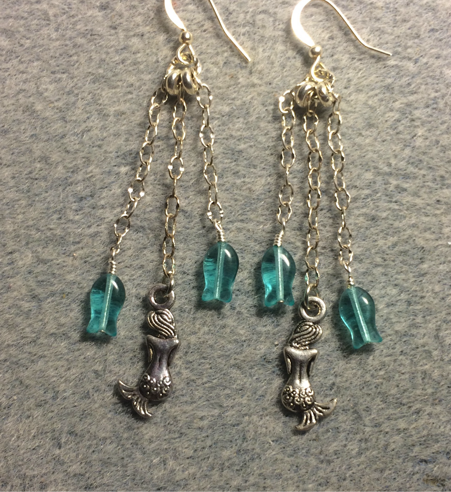 Small silver mermaid charm earrings attached to silver chain and adorned with small turquoise Czech glass fish beads