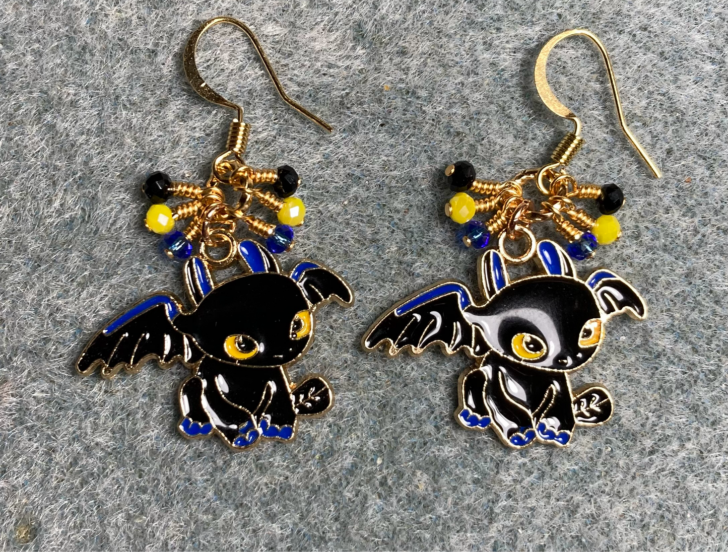 Black, blue, and yellow enamel dragon charm earrings adorned with tiny dangling black, blue, and yellow Chinese crystal beads