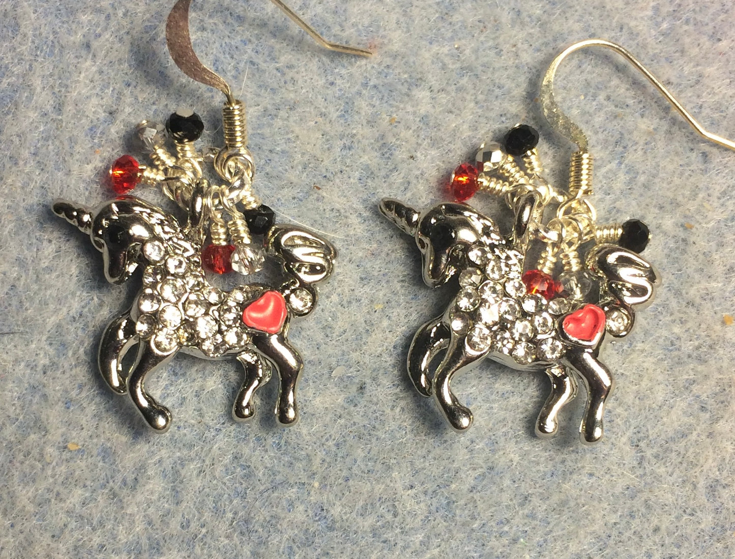 Silver and red enamel and rhinestone unicorn charm earrings adorned with small dangling silver, red, and black Chinese crystal beads.