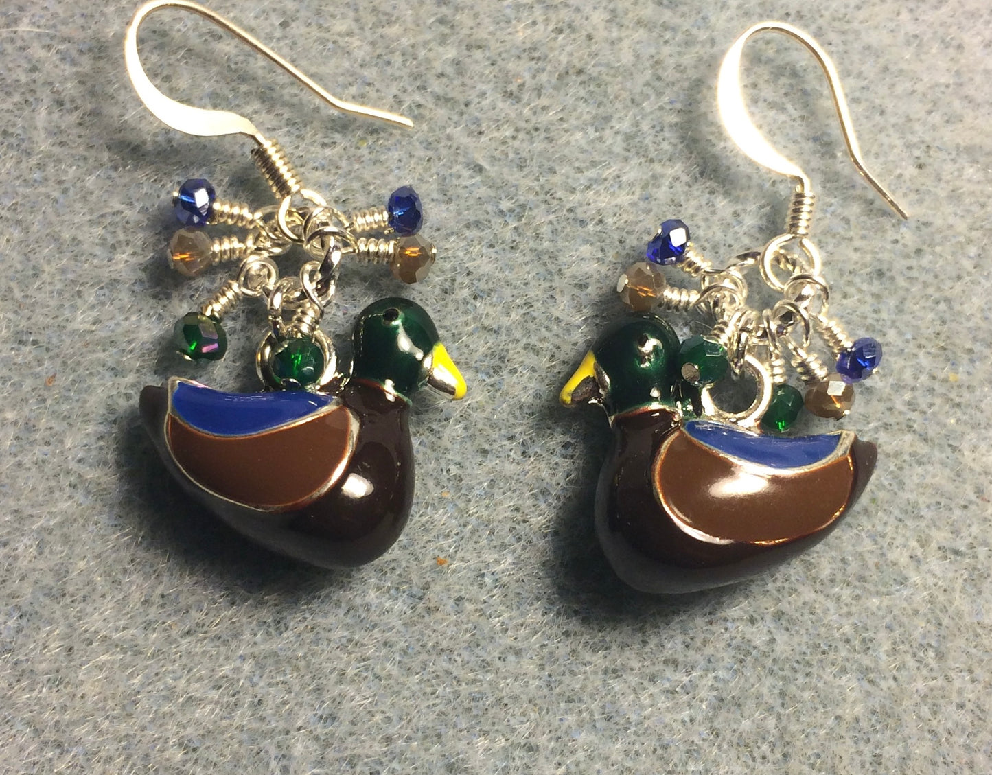 Brown, green, and dark blue enamel duck charm earrings adorned with tiny dangling brown, green, and dark blue Chinese crystal beads.