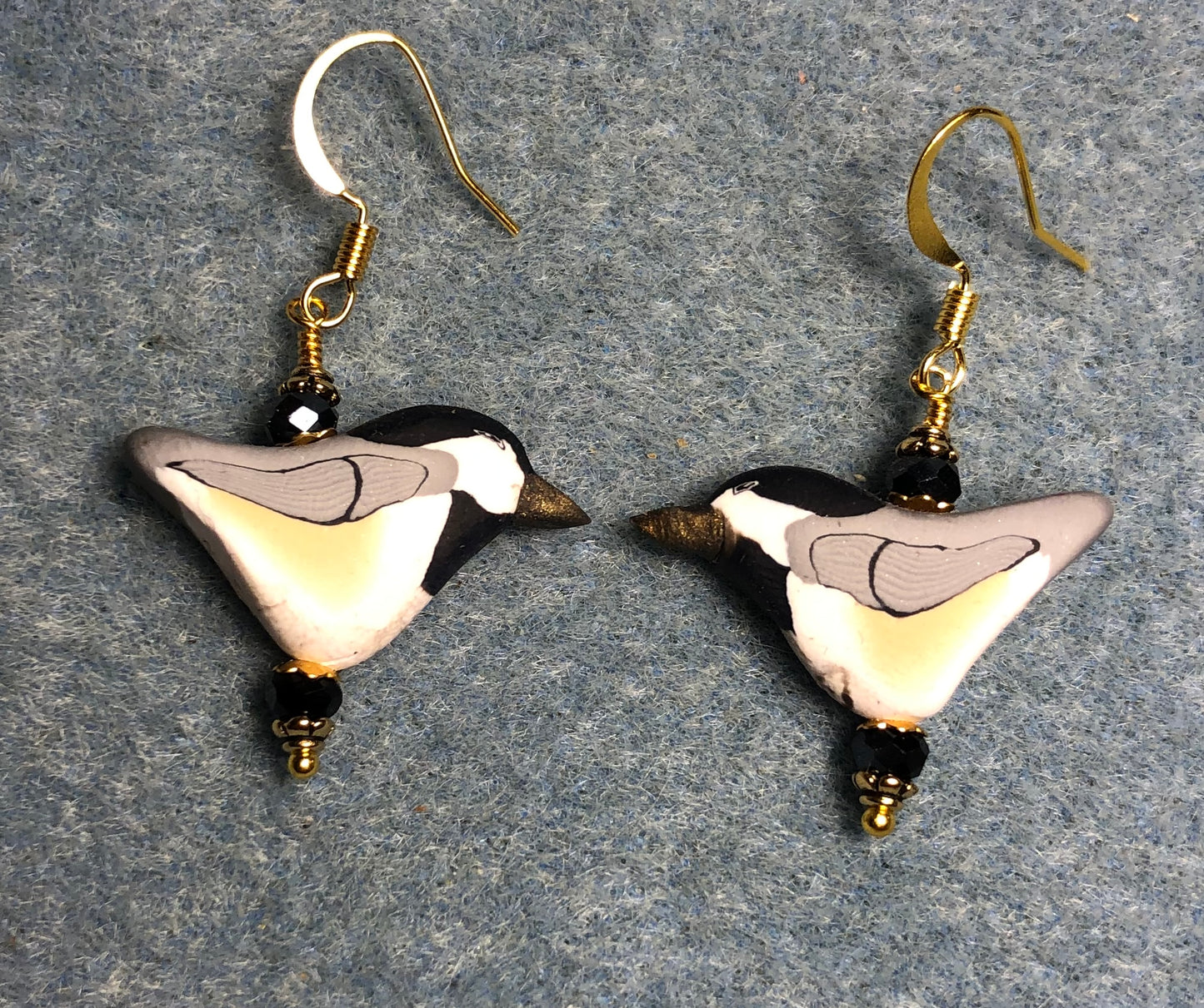 White, tan, and black polymer clay bird bead earrings adorned with black Chinese crystal beads.
