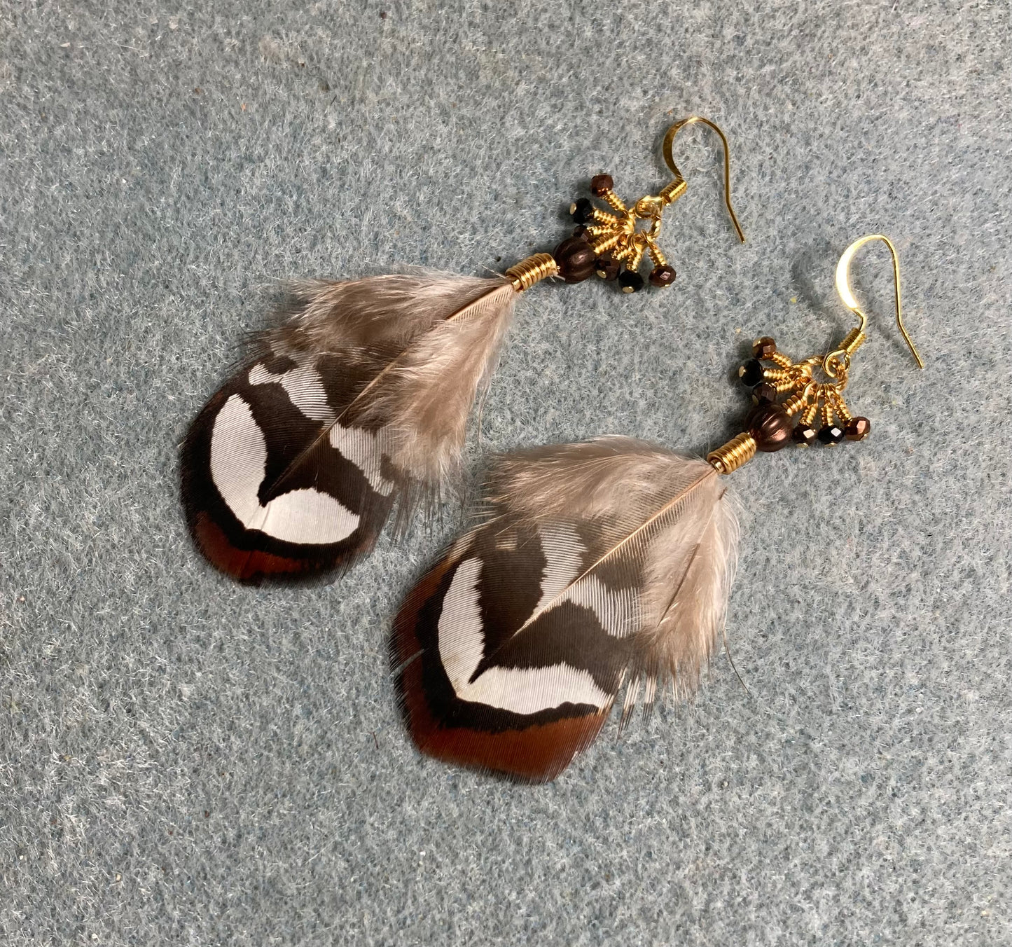 Brown Reeves pheasant feather earrings adorned with tiny dangling brown and black Chinese crystal beads.