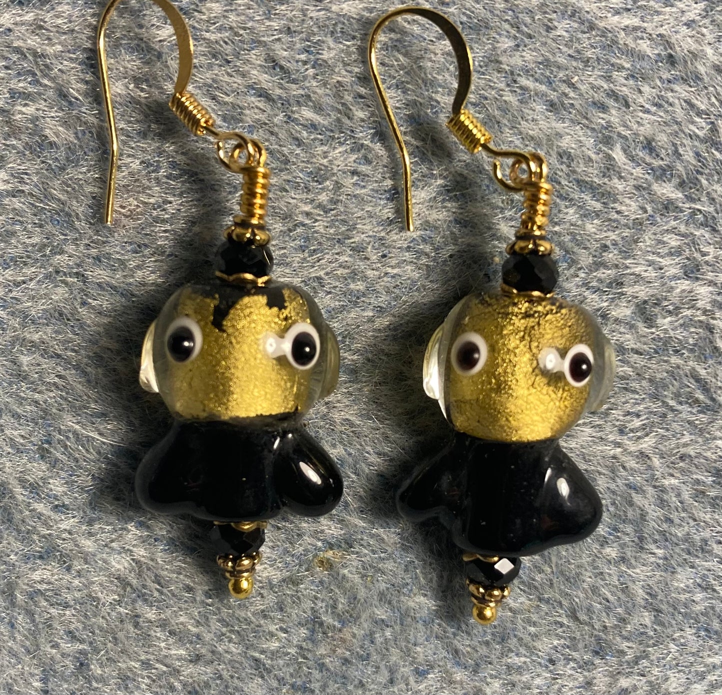 Black and gold lamp work fish bead earrings adorned with black Chinese crystal beads.