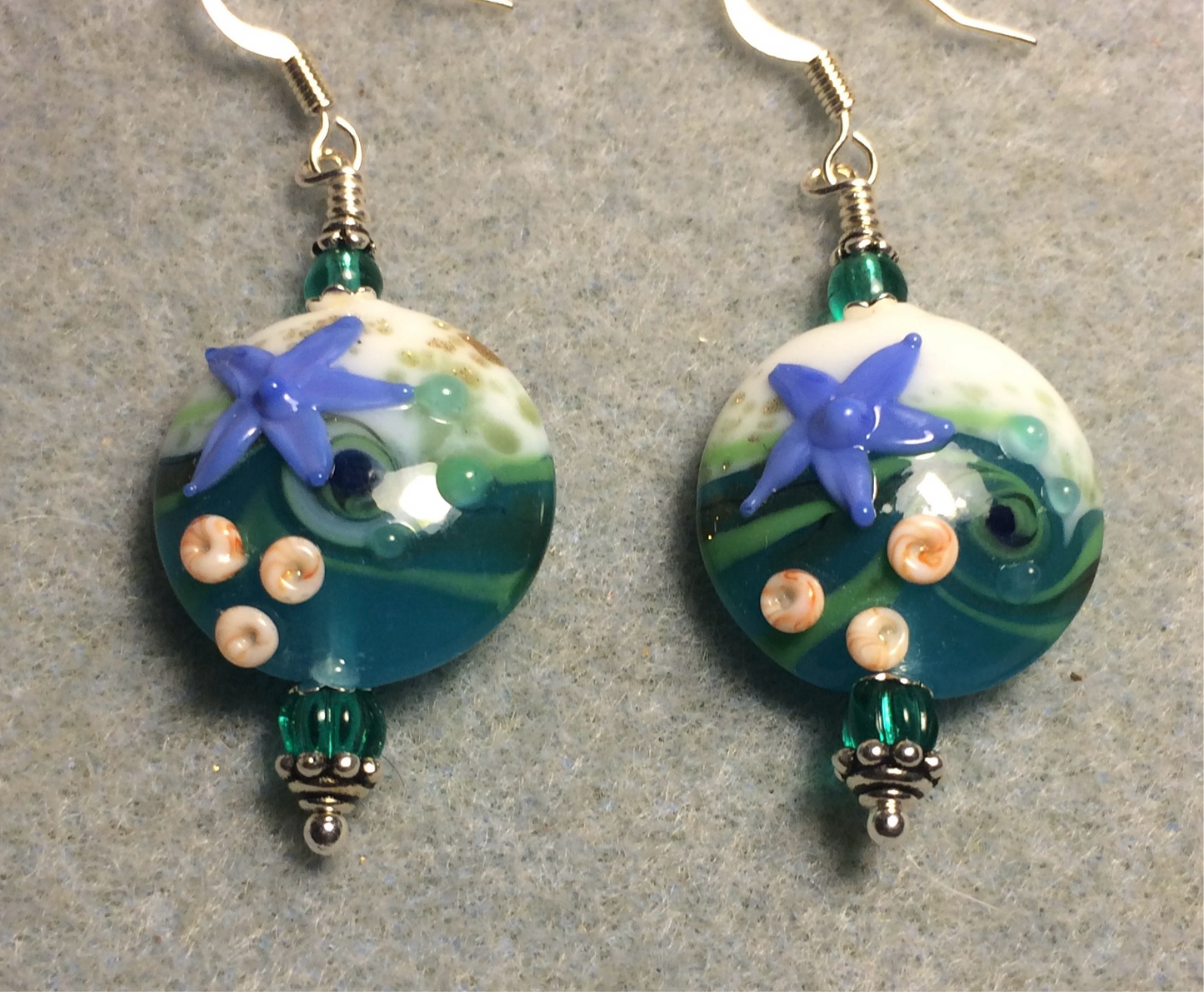 Teal, white, and blue lamp work starfish bead earrings adorned with teal Czech glass beads.