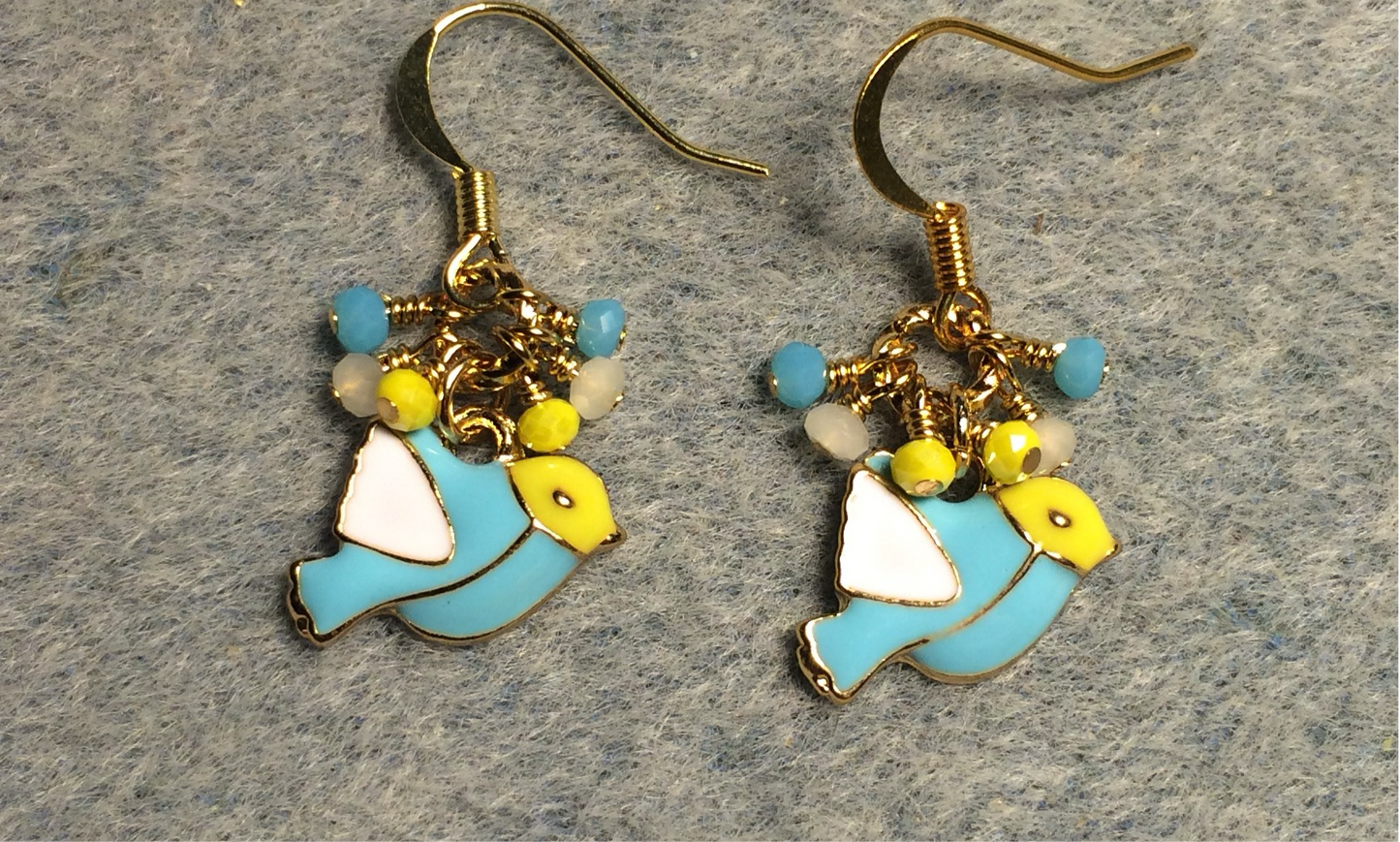 Small turquoise, yellow, and white enamel bird charm earrings adorned with tiny dangling turquoise, yellow, and white Chinese crystal beads.