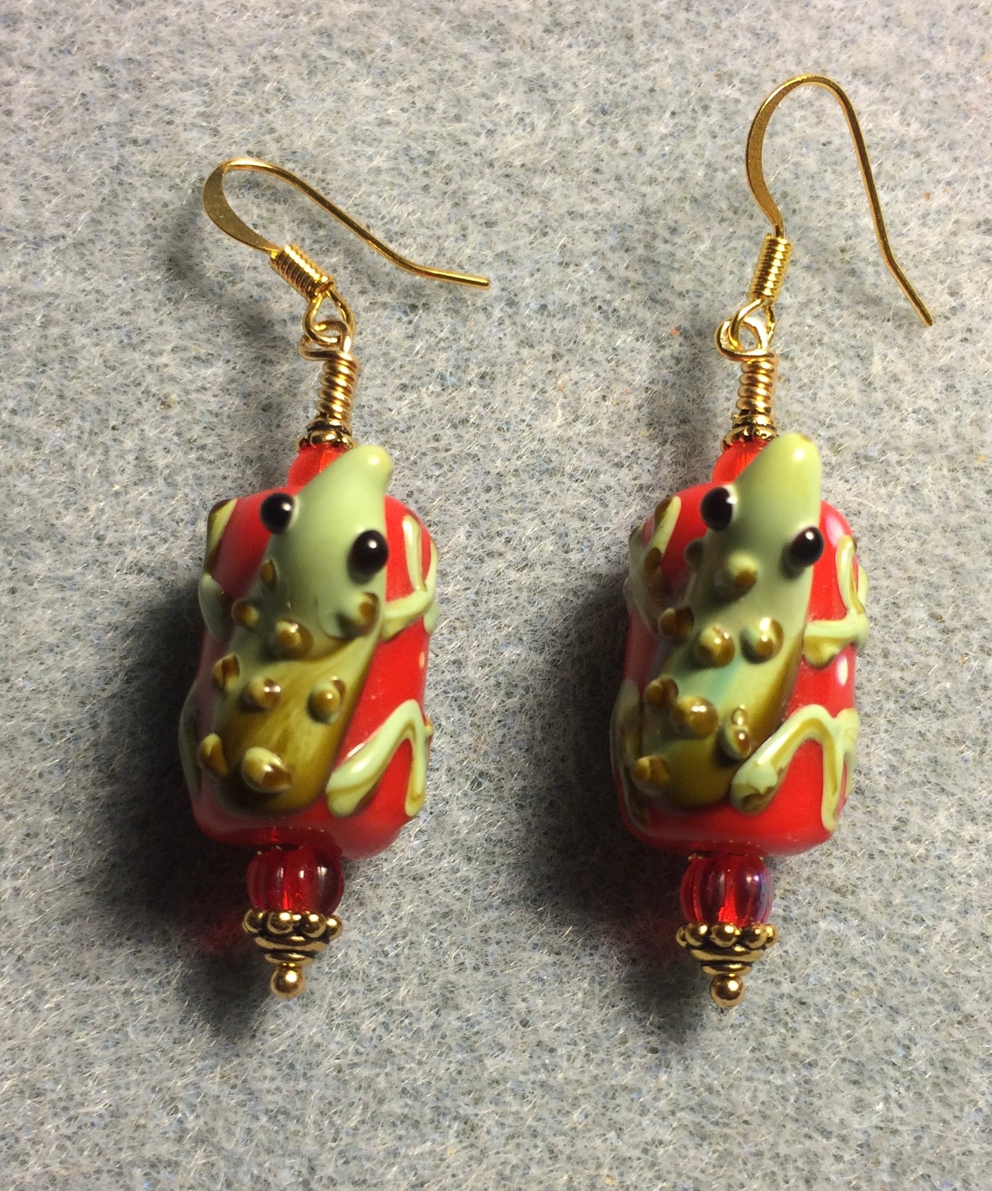 Bright red and green lamp work lizard bead earrings adorned with red Czech glass beads.