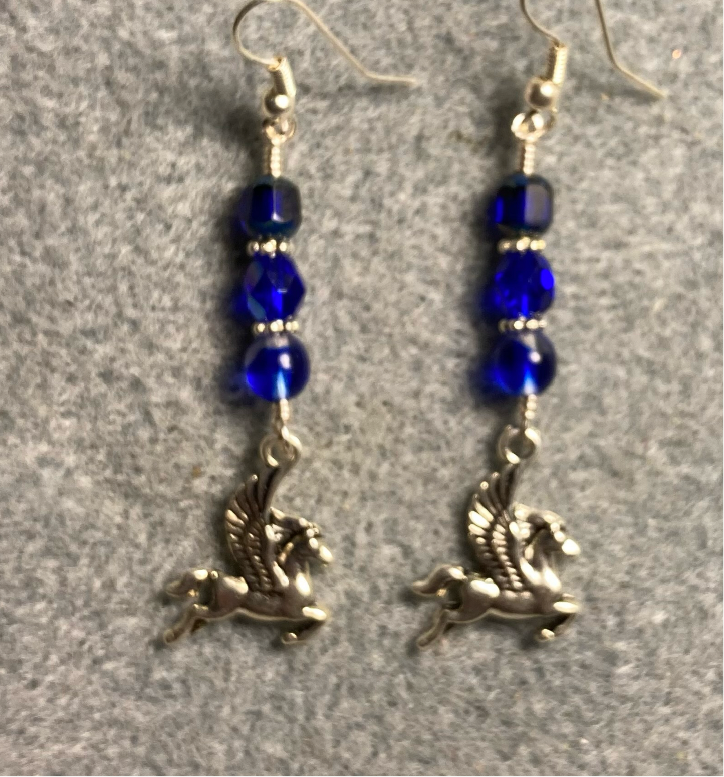 Silver Pegasus (flying horse) charm earrings adorned with dark blue Czech glass beads