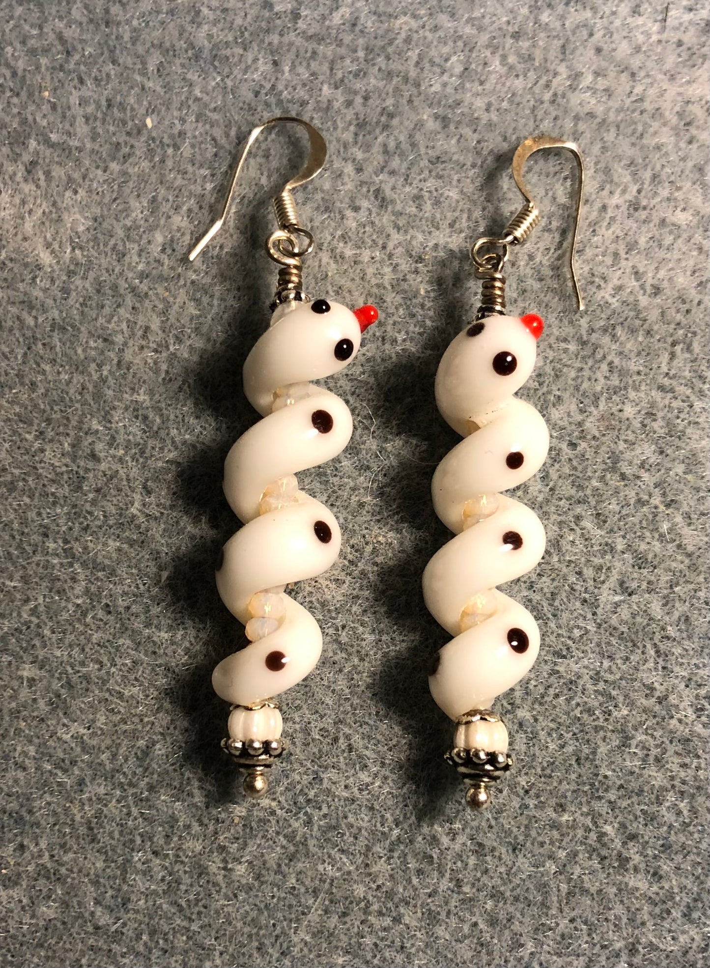 White lamp work coiled snake bead earrings adorned with white Czech glass beads and tiny white Chinese crystal beads.