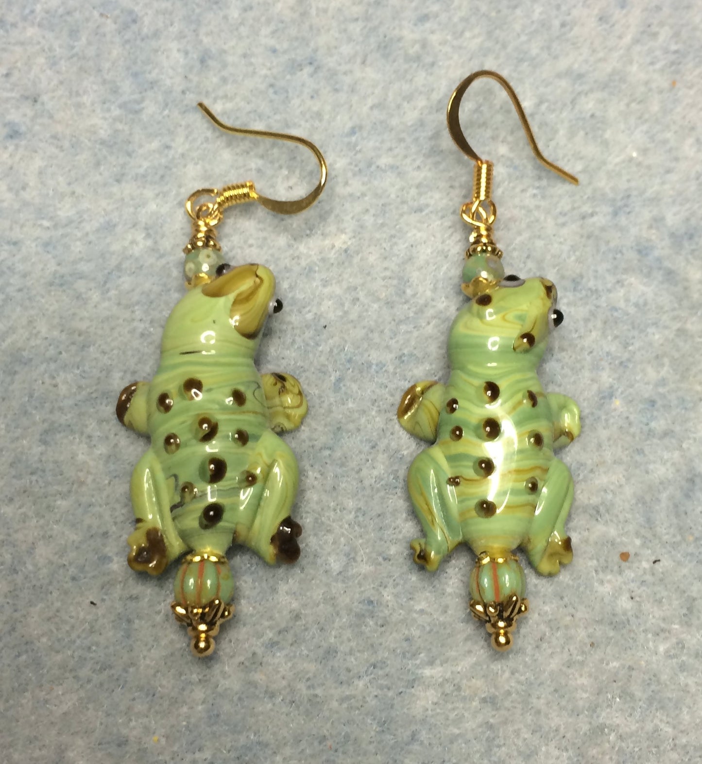 Green lamp work lizard bead earrings adorned with green Czech glass beads.