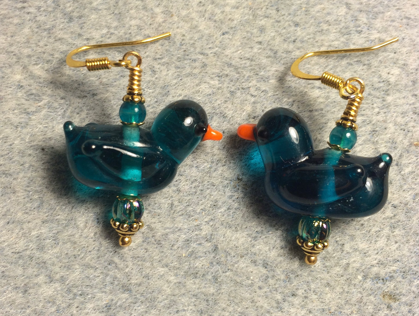 Translucent teal lamp work duck bead earrings adorned with teal Chinese crystal beads.