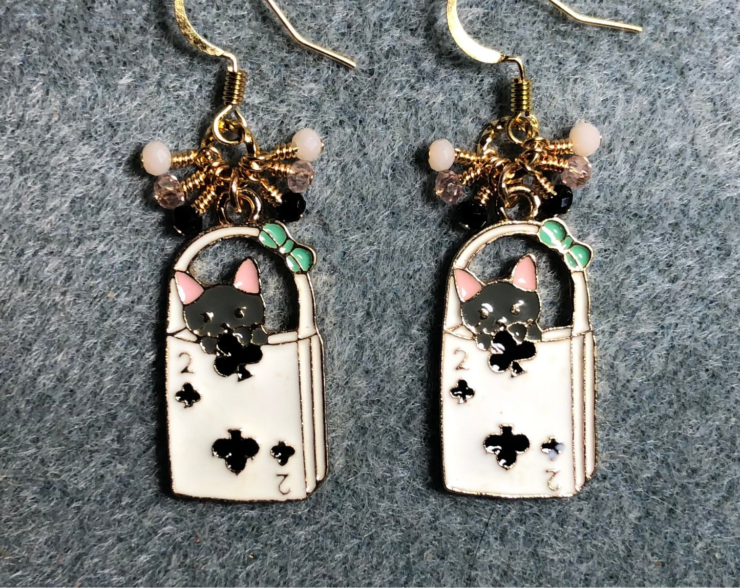 Black, pink, and white enamel cat charm earrings adorned with tiny dangling black, pink, and white Chinese crystal beads.