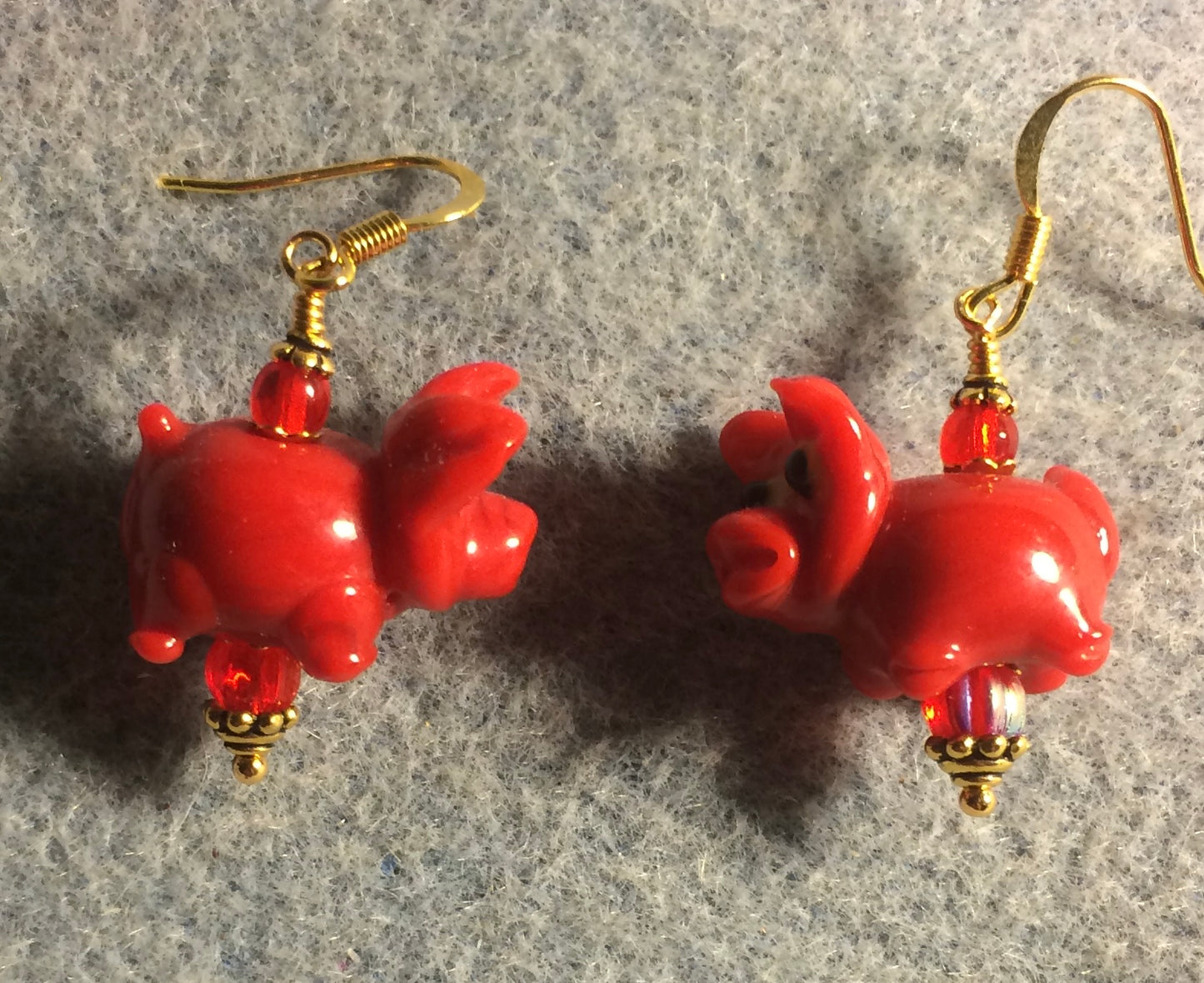Red lamp work pig bead earrings adorned with red Czech glass beads.