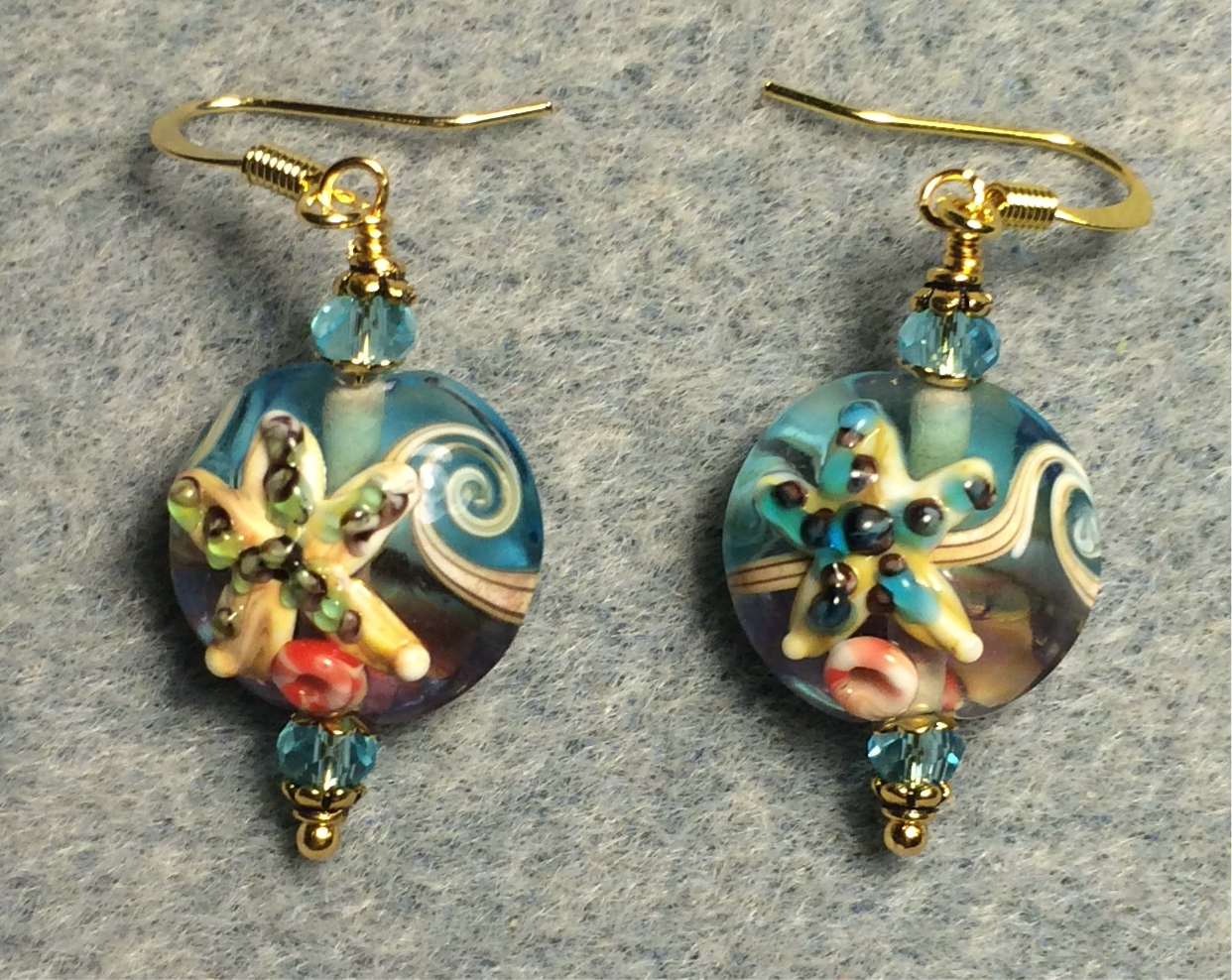 Turquoise and tan lamp work starfish bead earrings adorned with turquoise Chinese crystal beads.