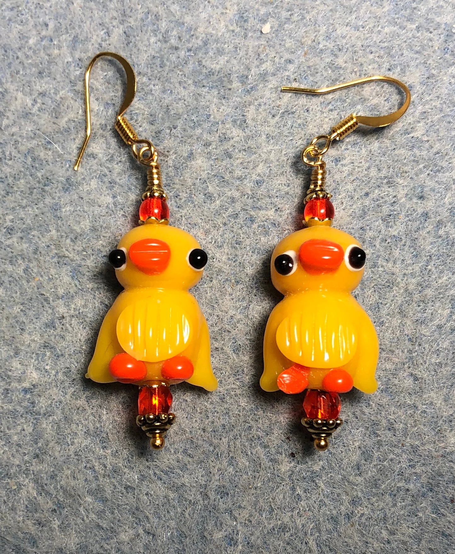 Golden yellow and orange lamp work duck bead earrings adorned with orange Czech glass beads.