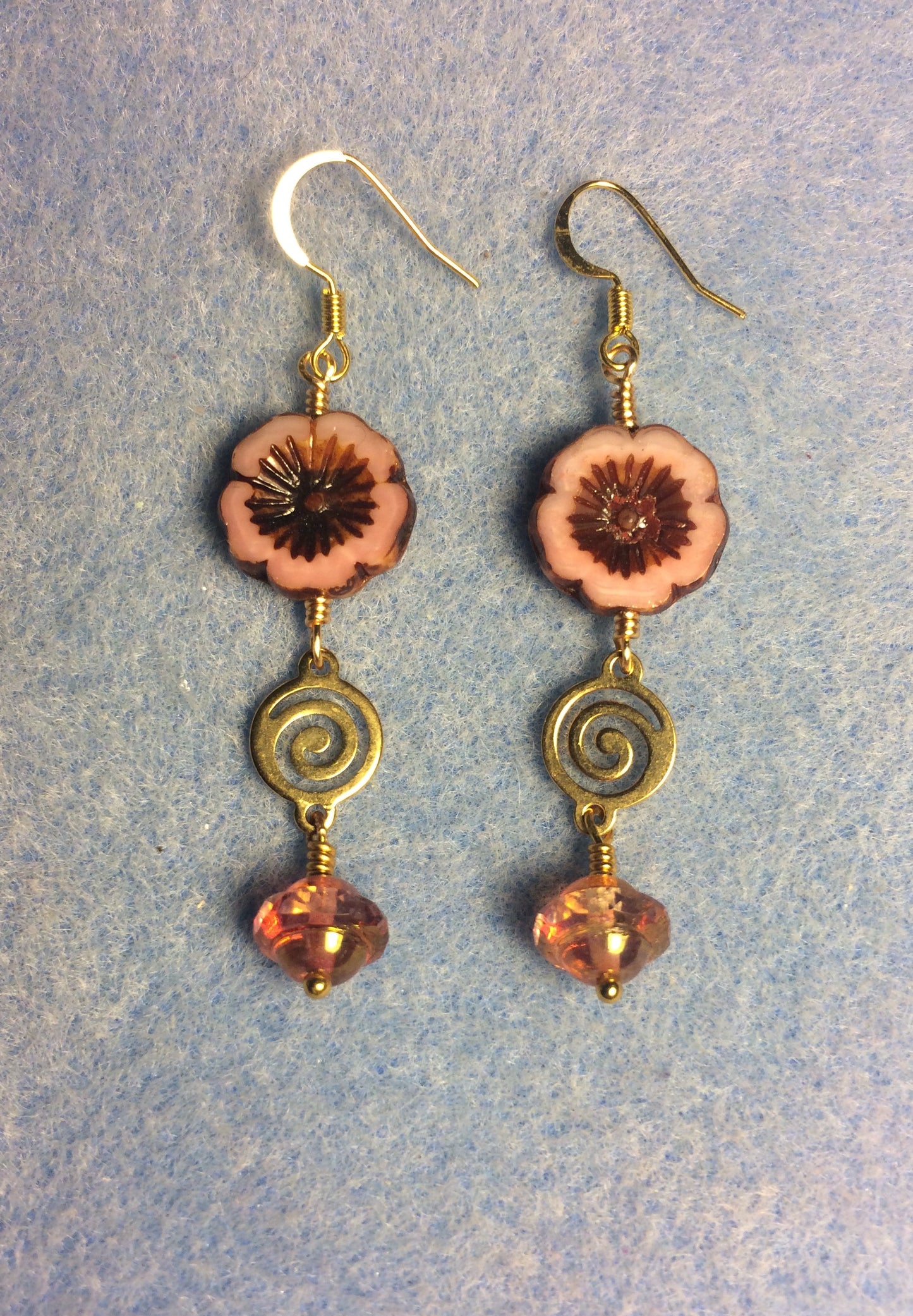 Peach Czech glass pansy bead earrings adorned with gold swirly connectors and peach Czech glass Saturn beads.