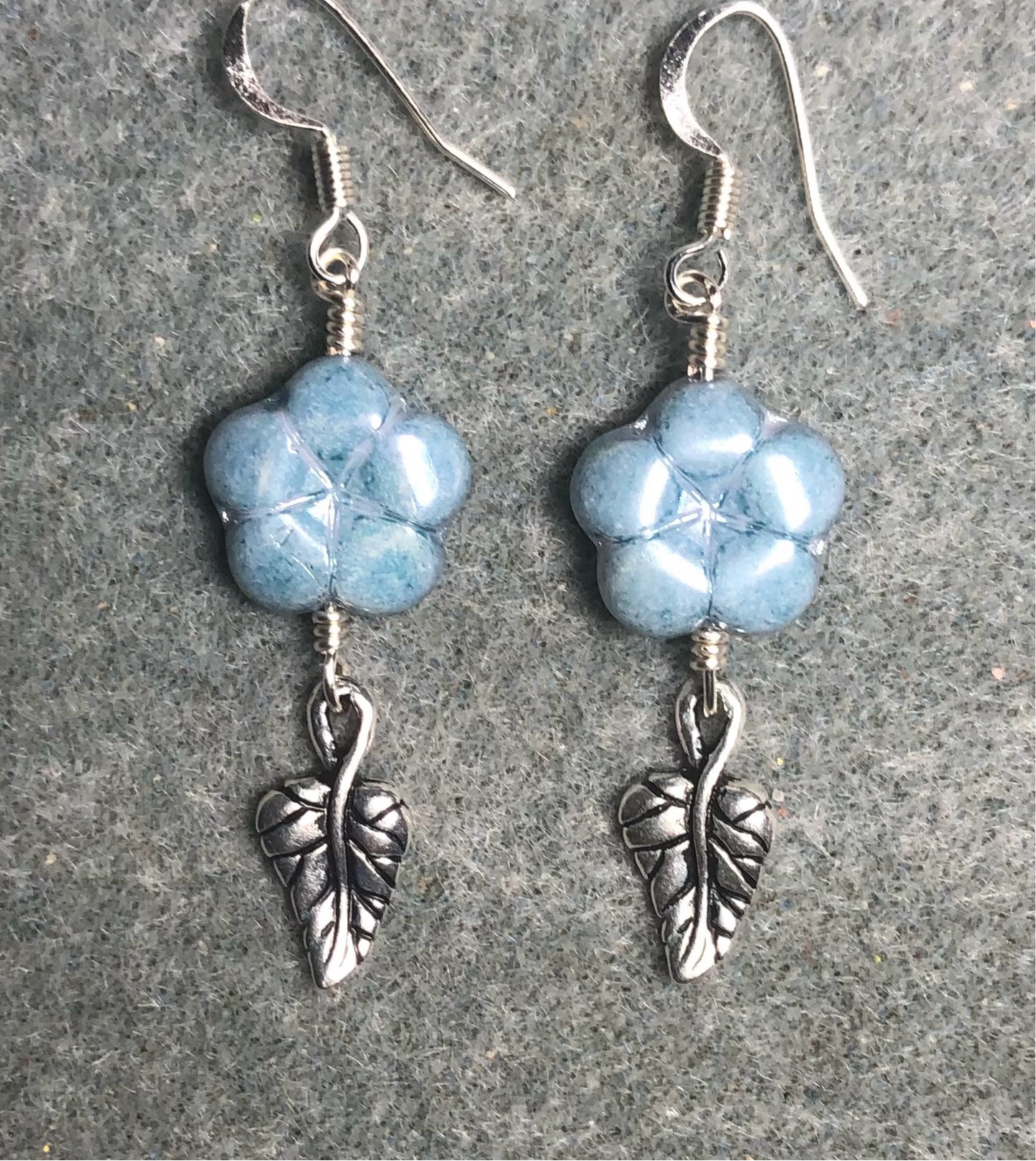 Light blue Czech glass puffy flower bead earrings adorned with silver Tierracast leaf charms.