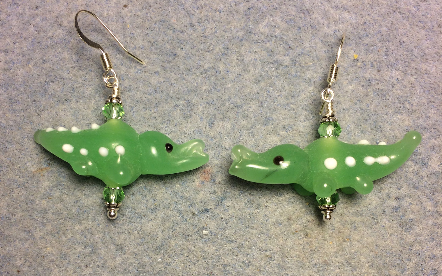 Milky green lamp work spotted alligator bead earrings adorned with green Chinese crystal beads.
