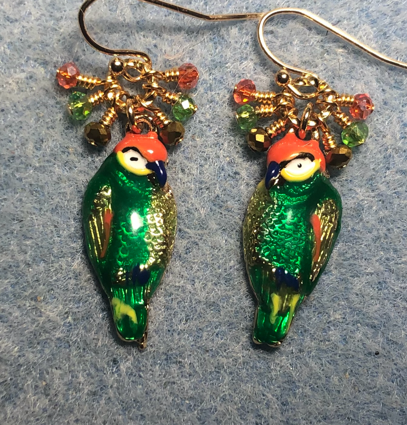 Vintage green, orange, and gold enamel parrot charm earrings adorned with tiny dangling green, orange, and gold Chinese crystal beads.