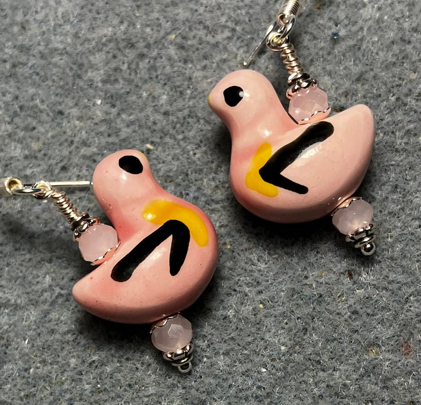 Pink, black, and yellow ceramic duck bead earrings adorned with pink Chinese crystal beads.