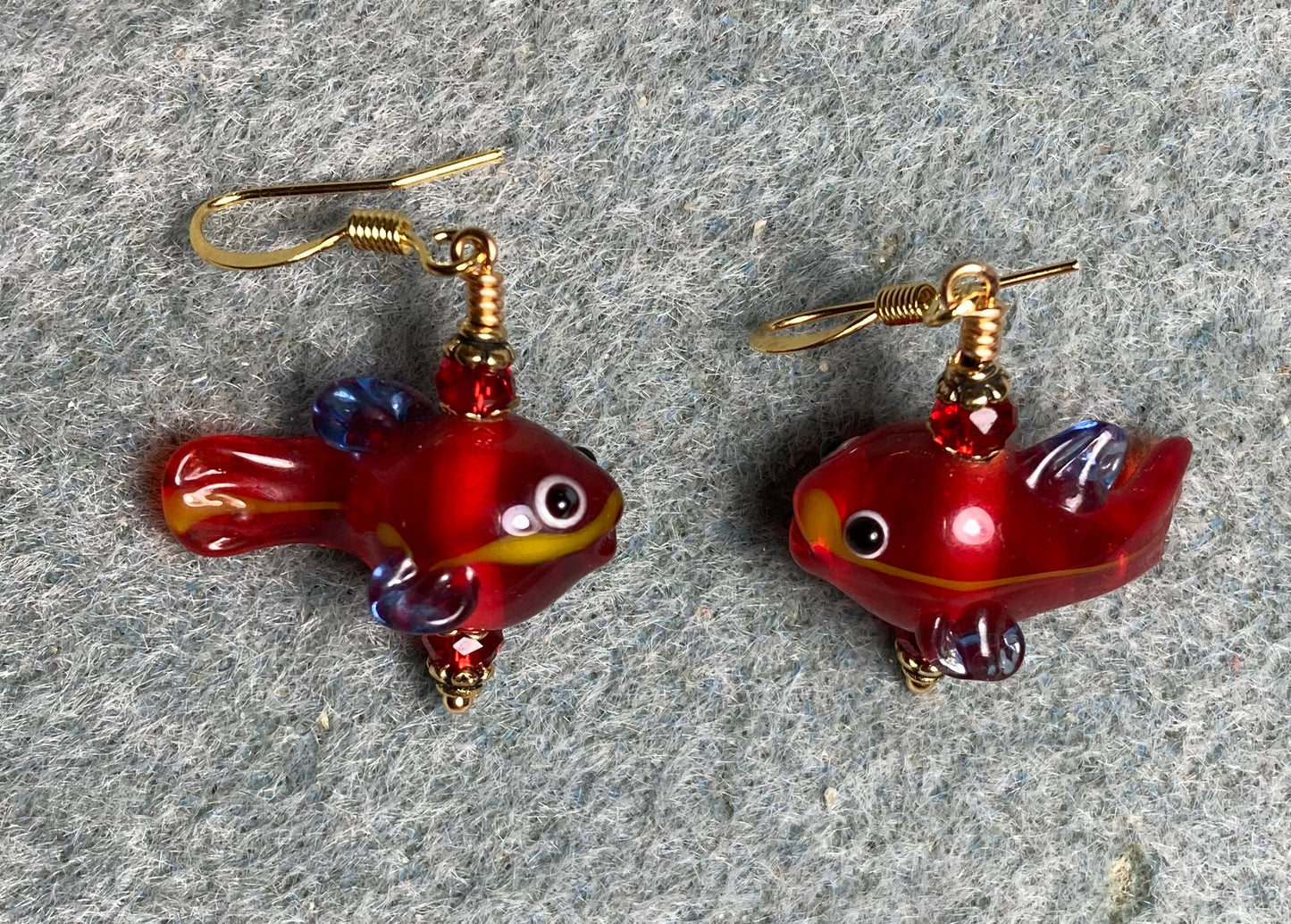 Small translucent red lamp work fish bead earrings adorned with red Chinese crystal beads.